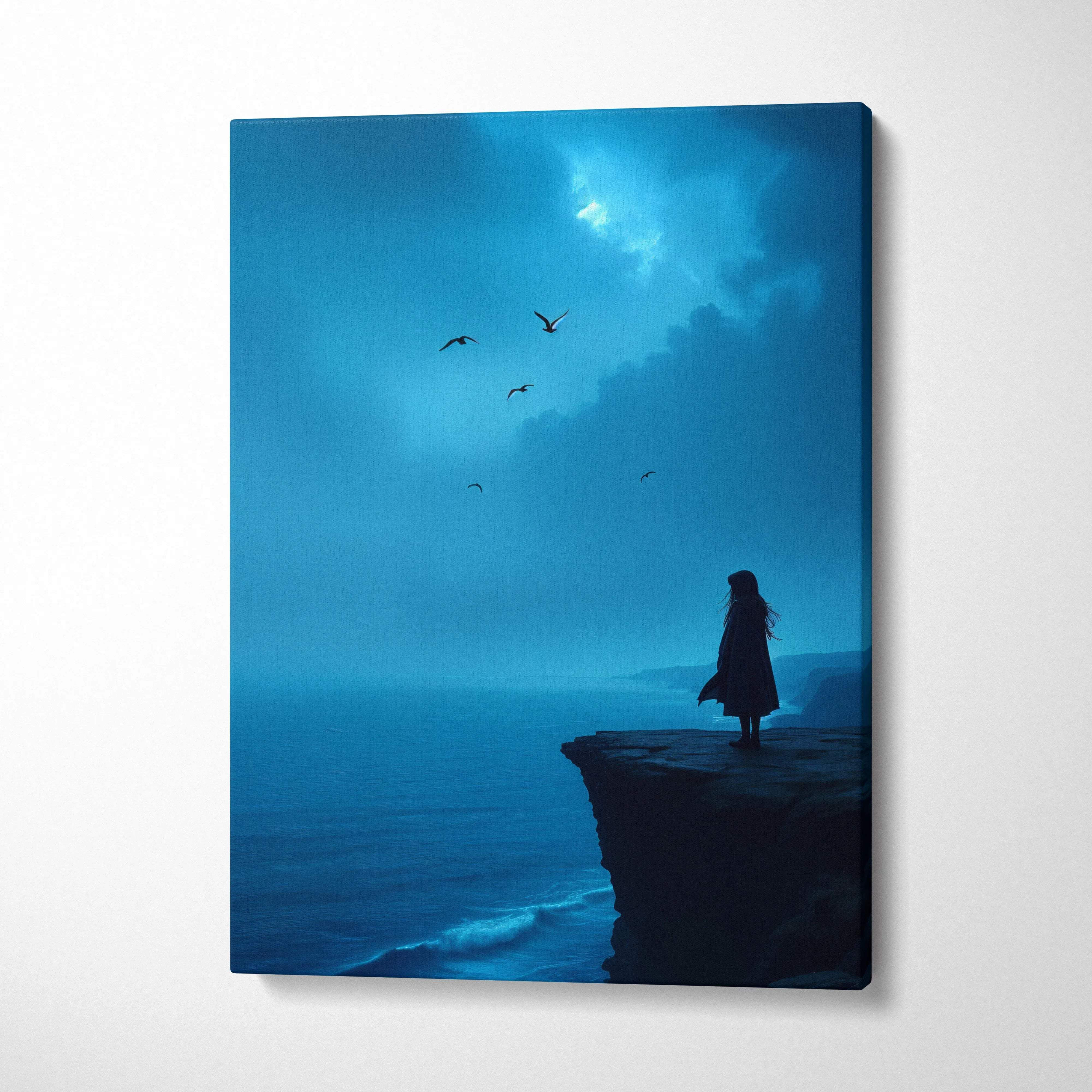 Blue-toned canvas wall art of solitary figure on coastal cliff overlooking moody ocean