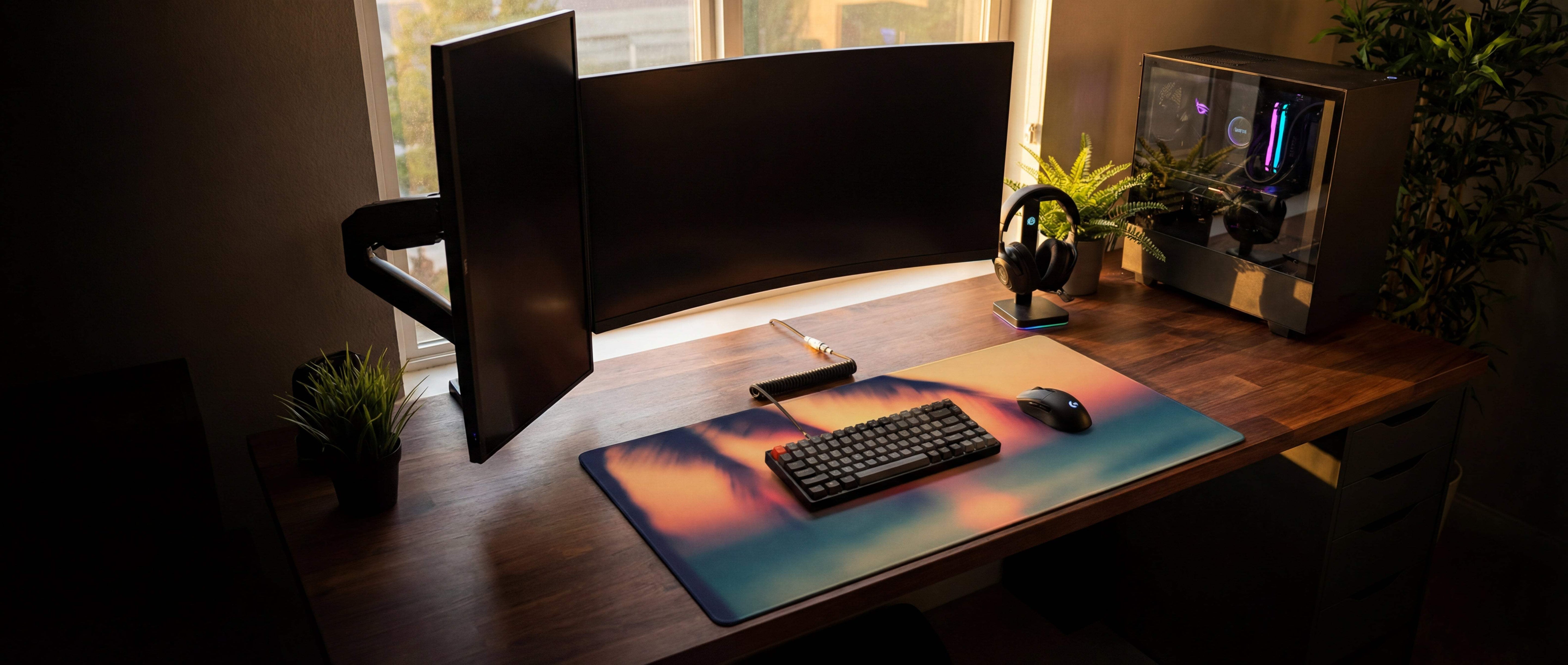 A rectangular gaming mousepad with a vibrant sunset design featuring orange, pink, and blue gradients.