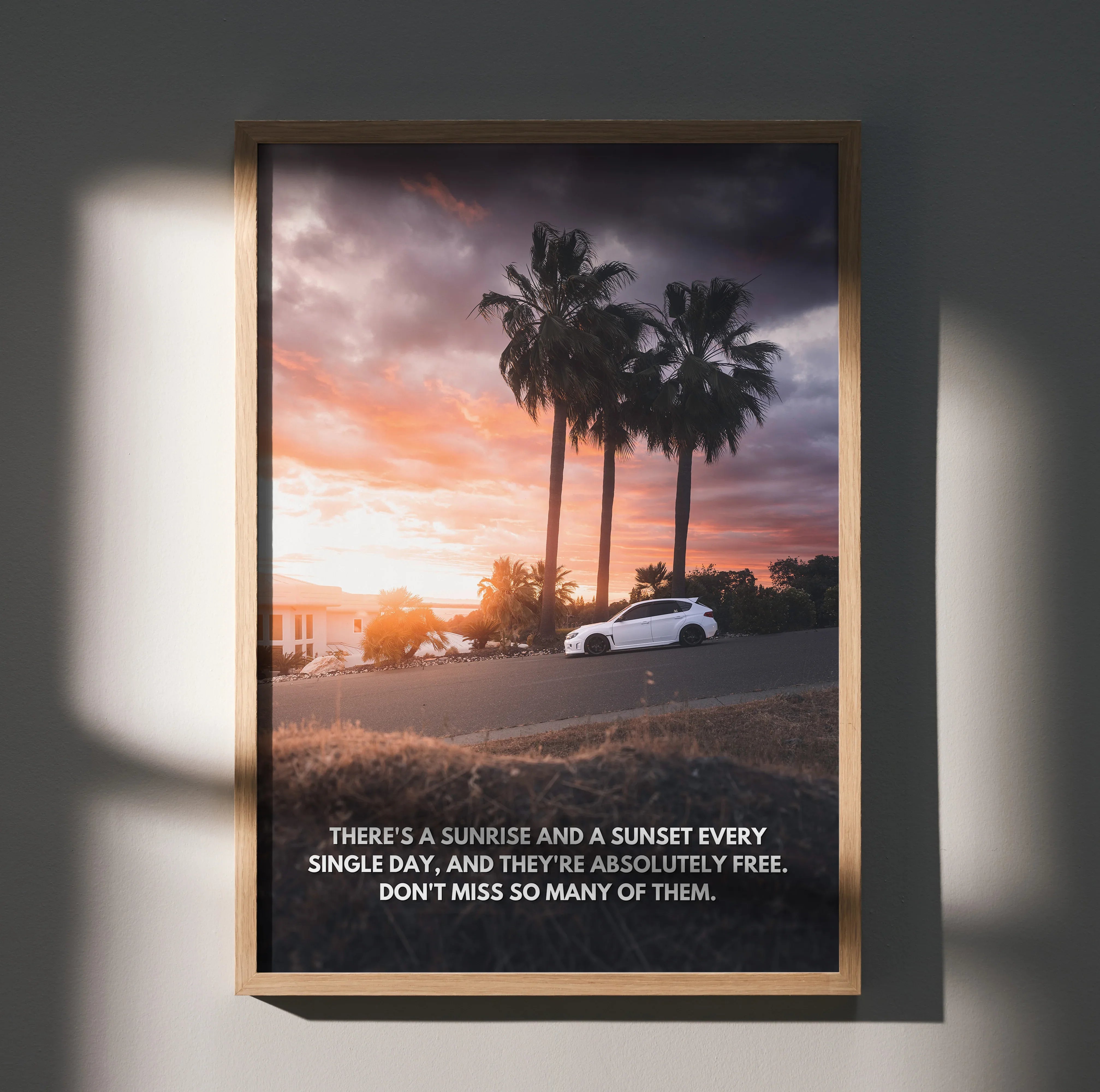 Motivational poster wall art with Subaru WRX STI car at sunset and inspiring text beneath palm trees.