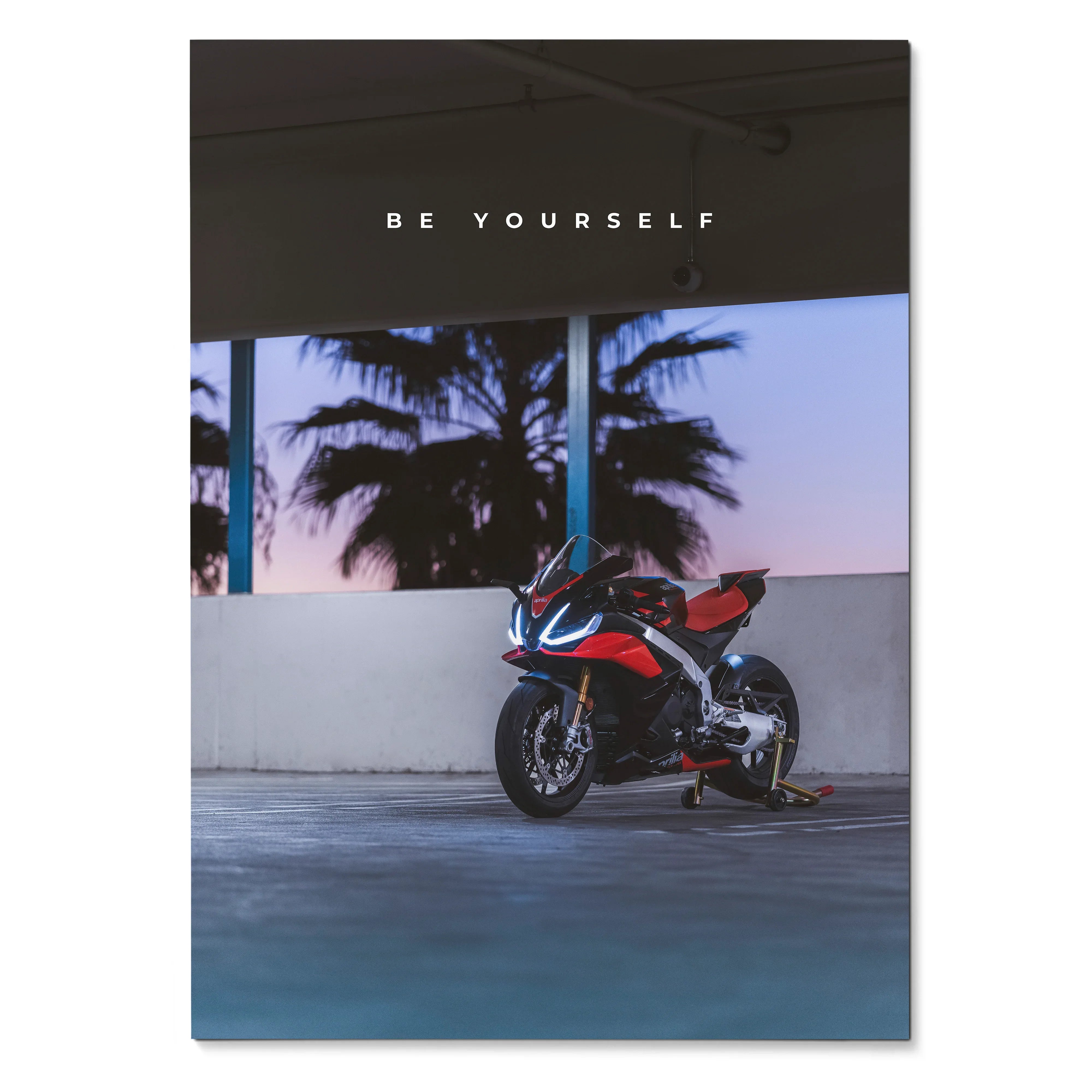 Motivational poster featuring Aprilia RSV4 1100 Factory motorcycle against palm trees at sunset wall art.