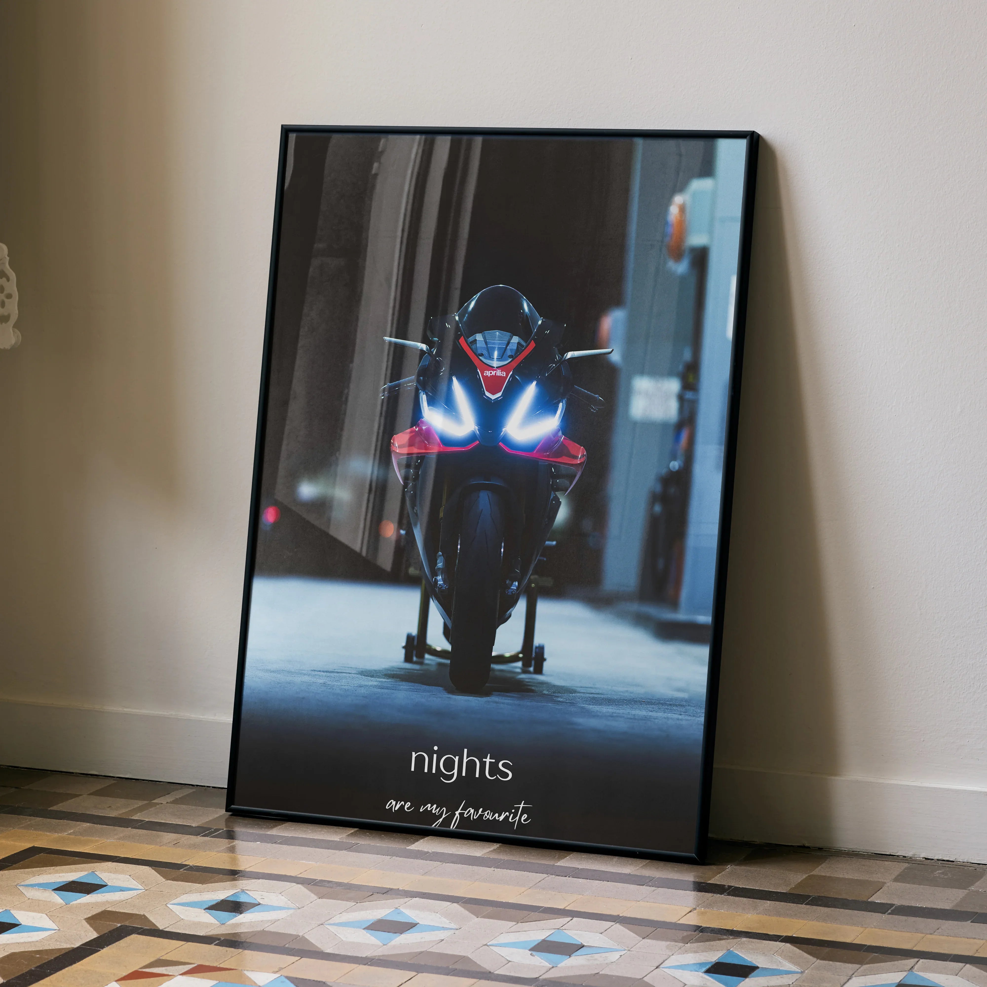 Aprilia RSV4 1100 Factory motorcycle lit at night poster wall art in black frame.