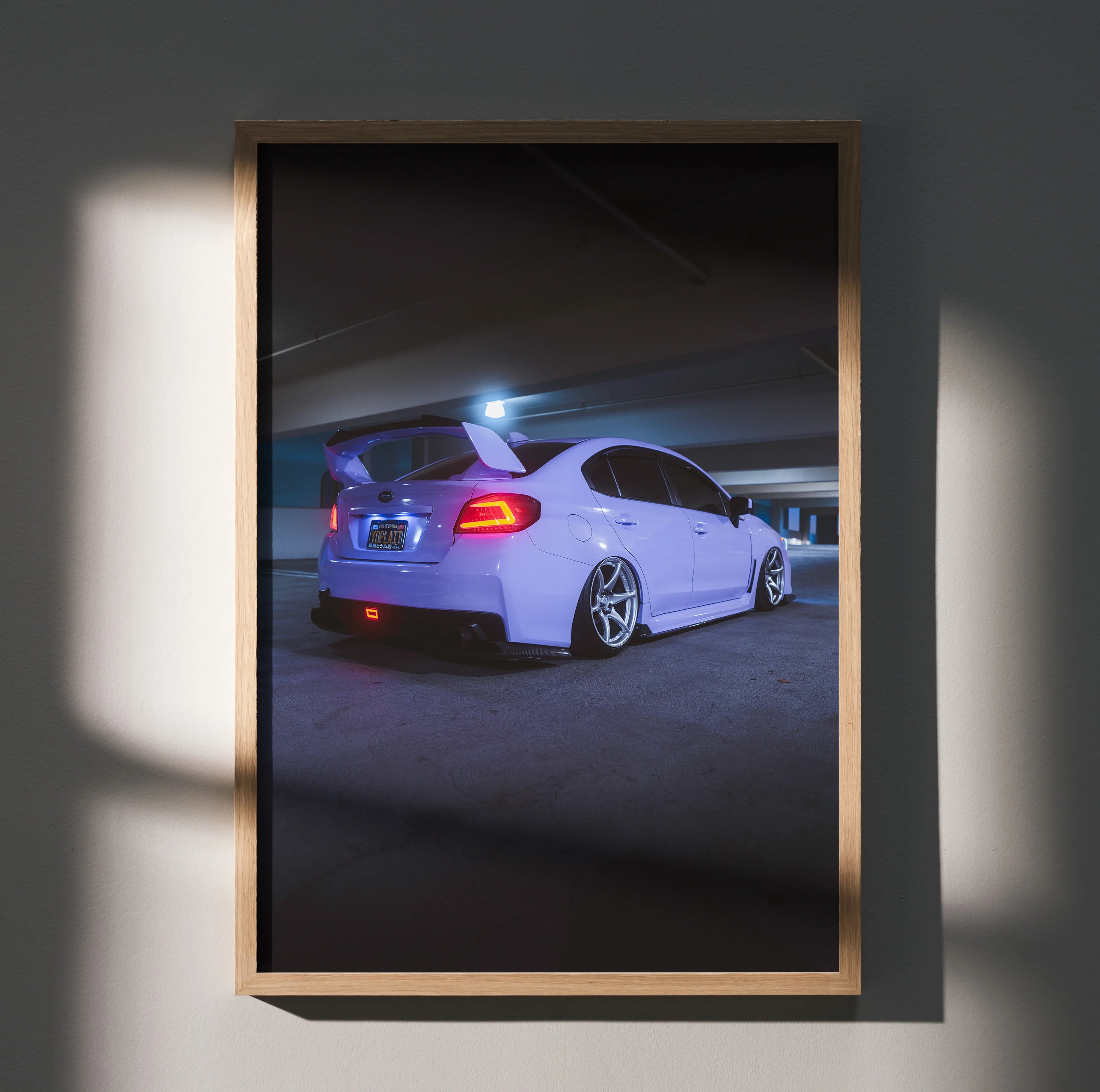Subaru WRX rear view poster showcasing lowered white car with sporty rims, wall art in wooden frame.