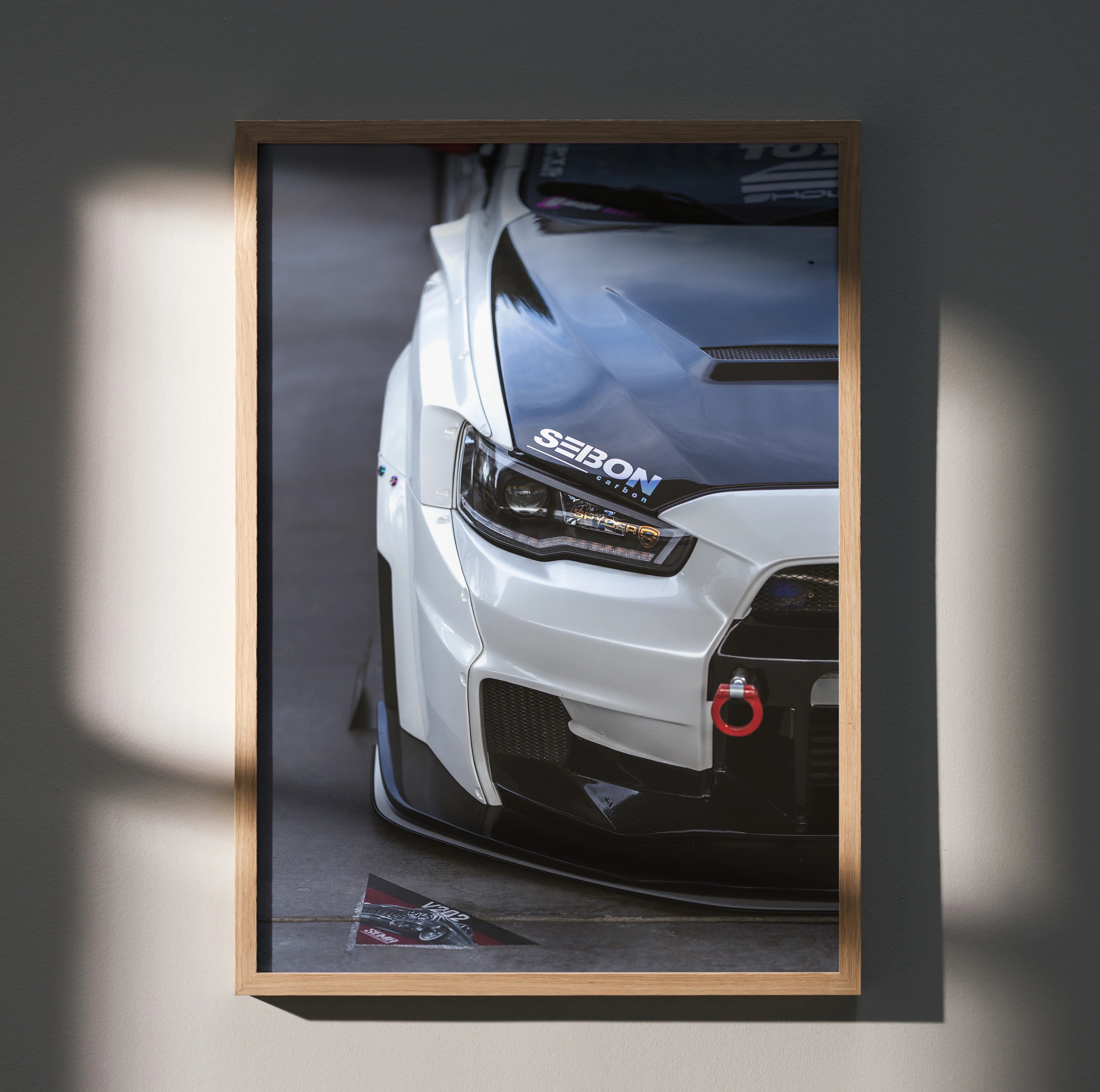 Mitsubishi Evo 10 front close-up poster with carbon hood and red tow hook wall art.