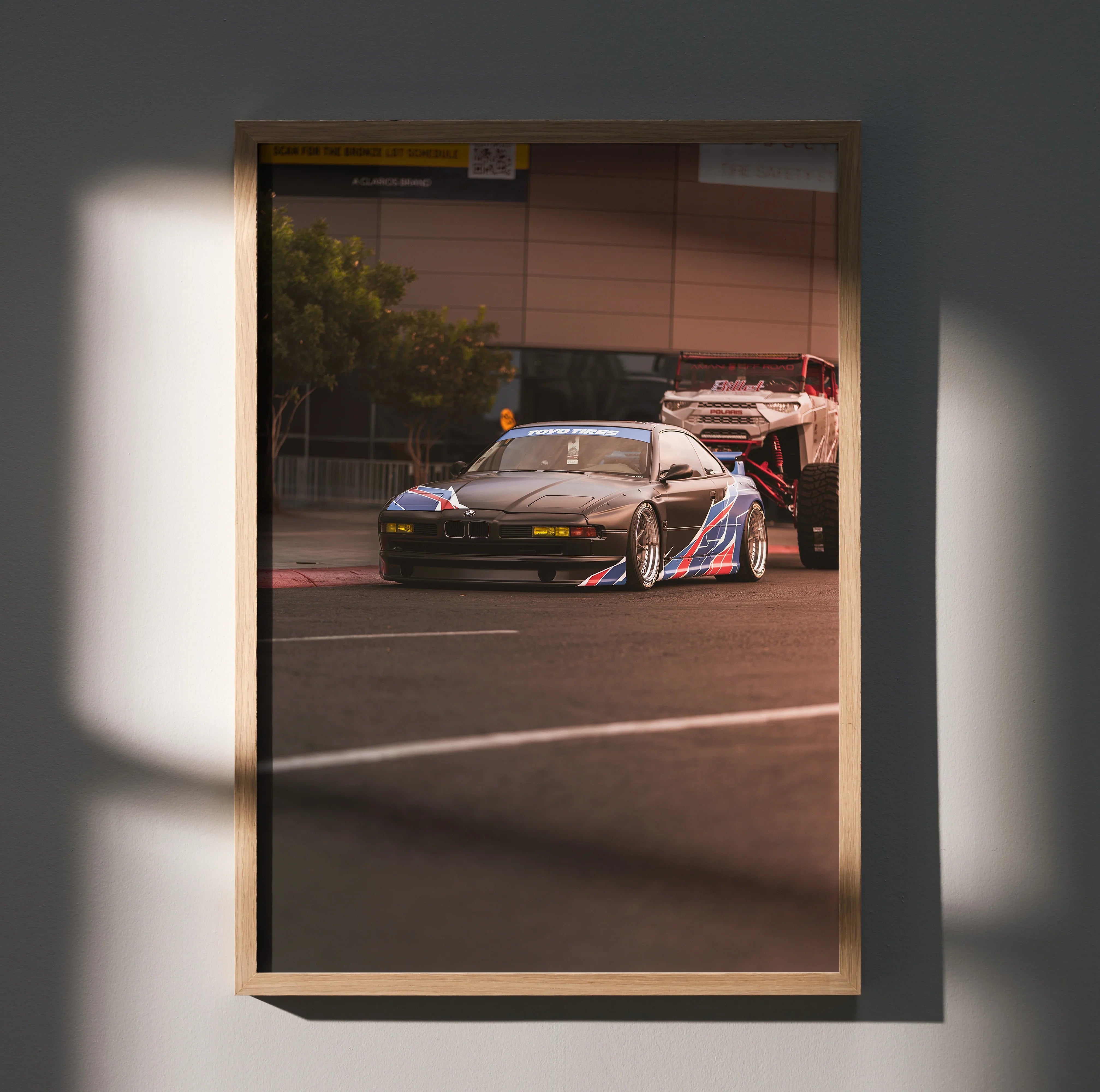BMW E31 850ci racing car poster with bold red, blue, and white decal wall art in wooden frame.
