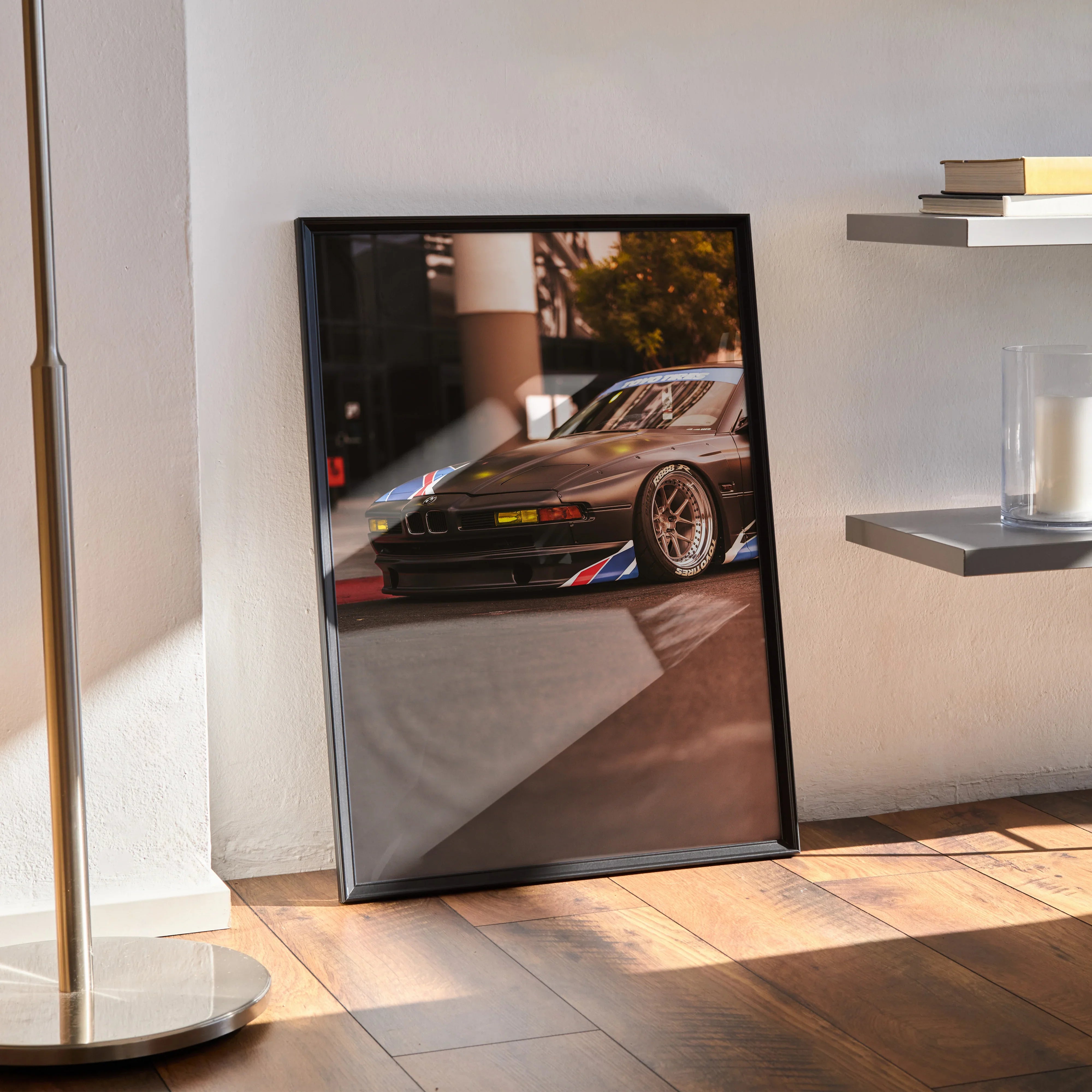 Framed BMW E31 850ci classic car poster leaning against wall, automotive wall art with glossy finish.