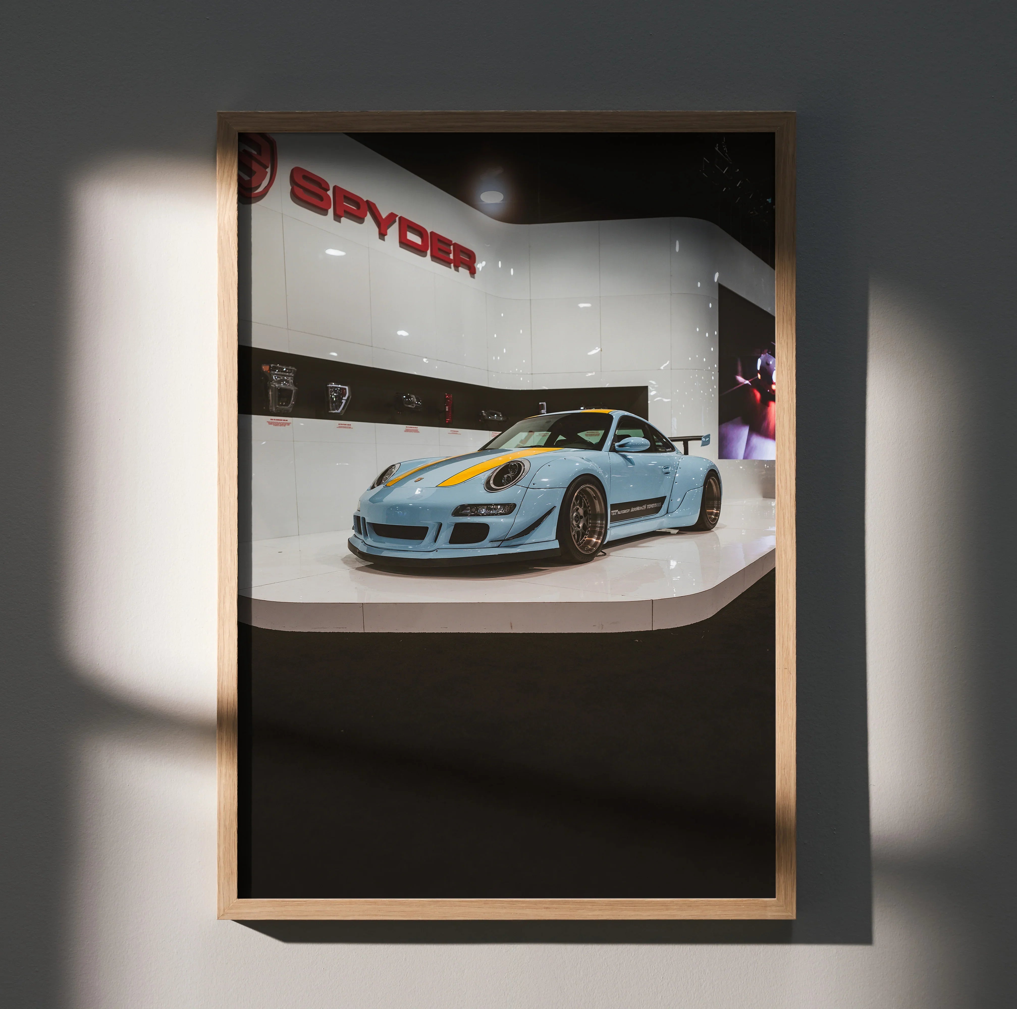 Porsche 911 Carrera 4 in light blue displayed in modern showroom poster wall art with subtle shadow effect.