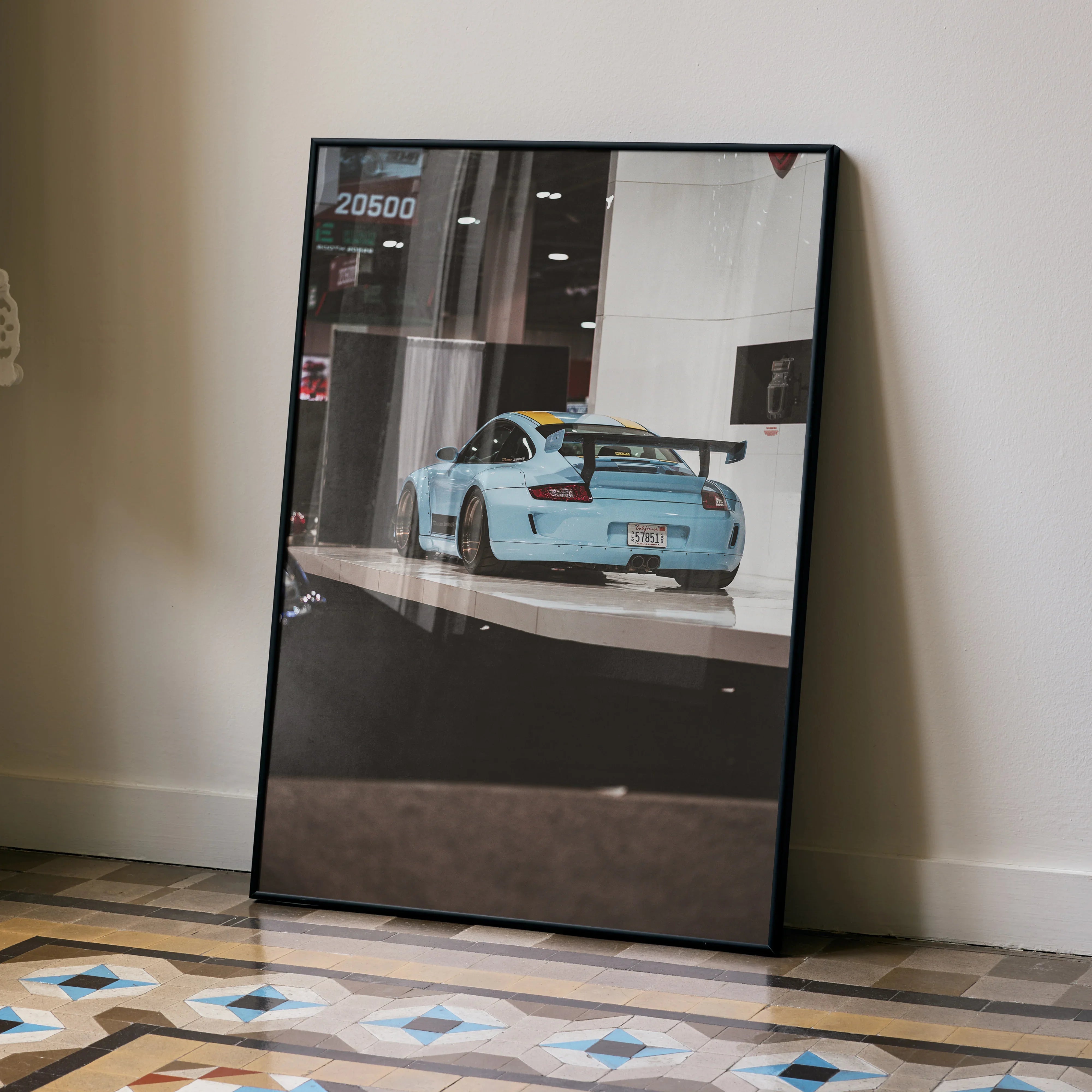 Porsche 911 Carrera 4 blue sports car poster leaning on wall with glossy finish wall art.