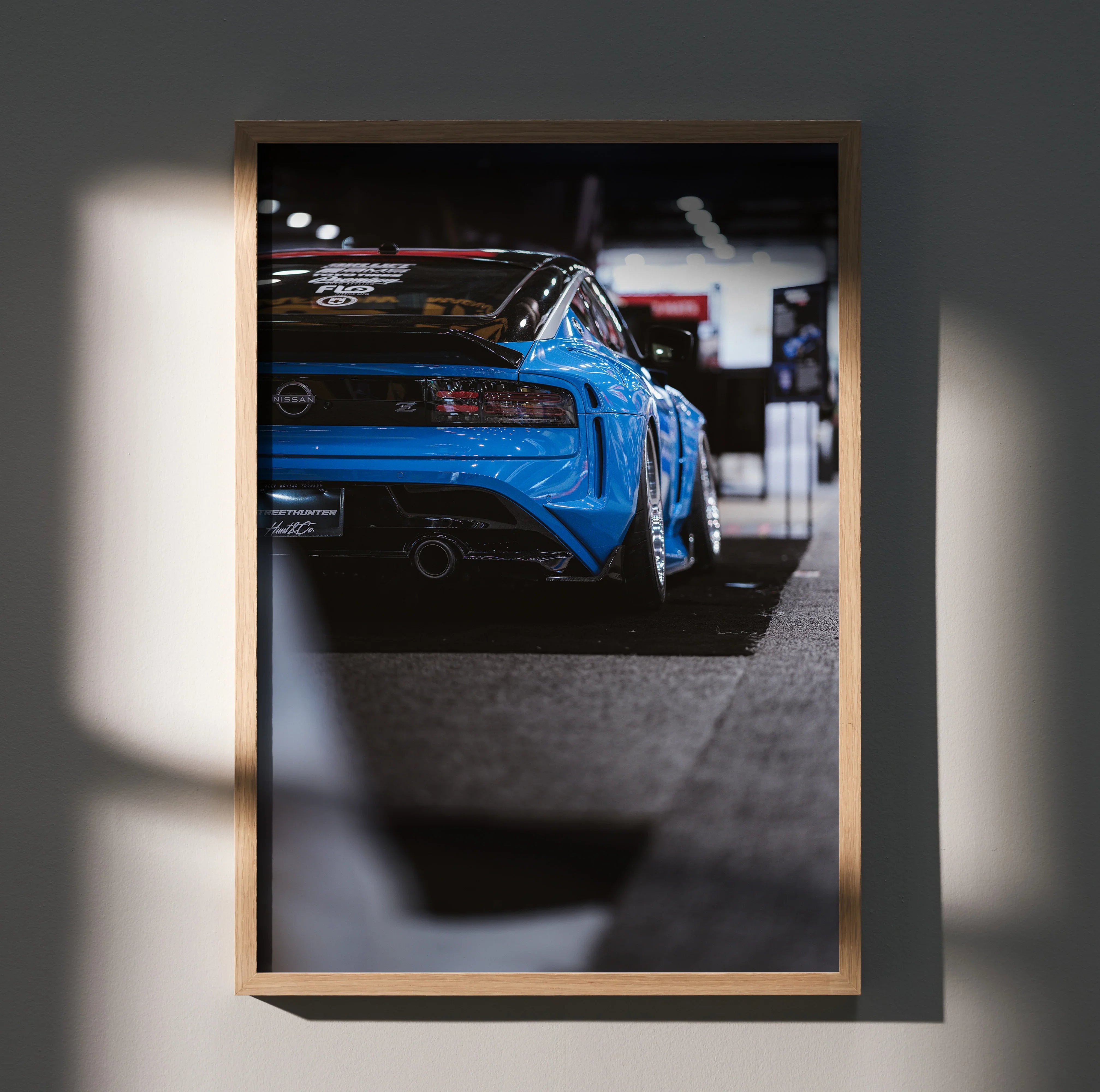 Nissan Z (RZ34) rear view in vibrant blue, sleek automotive poster wall art with modern garage backdrop.