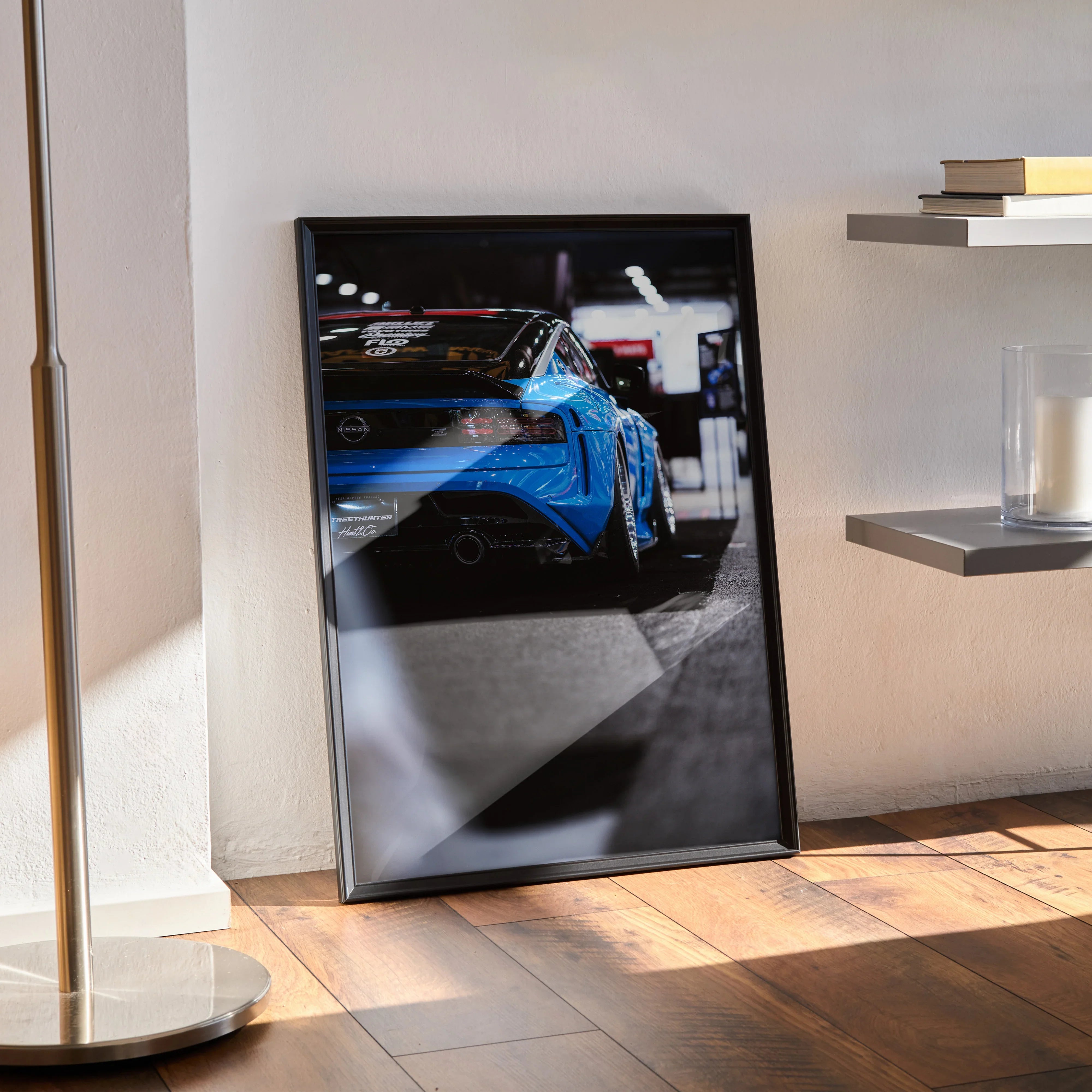 Nissan Z (RZ34) poster showing blue sports car rear in high-resolution wall art with sleek black frame, modern room setting.