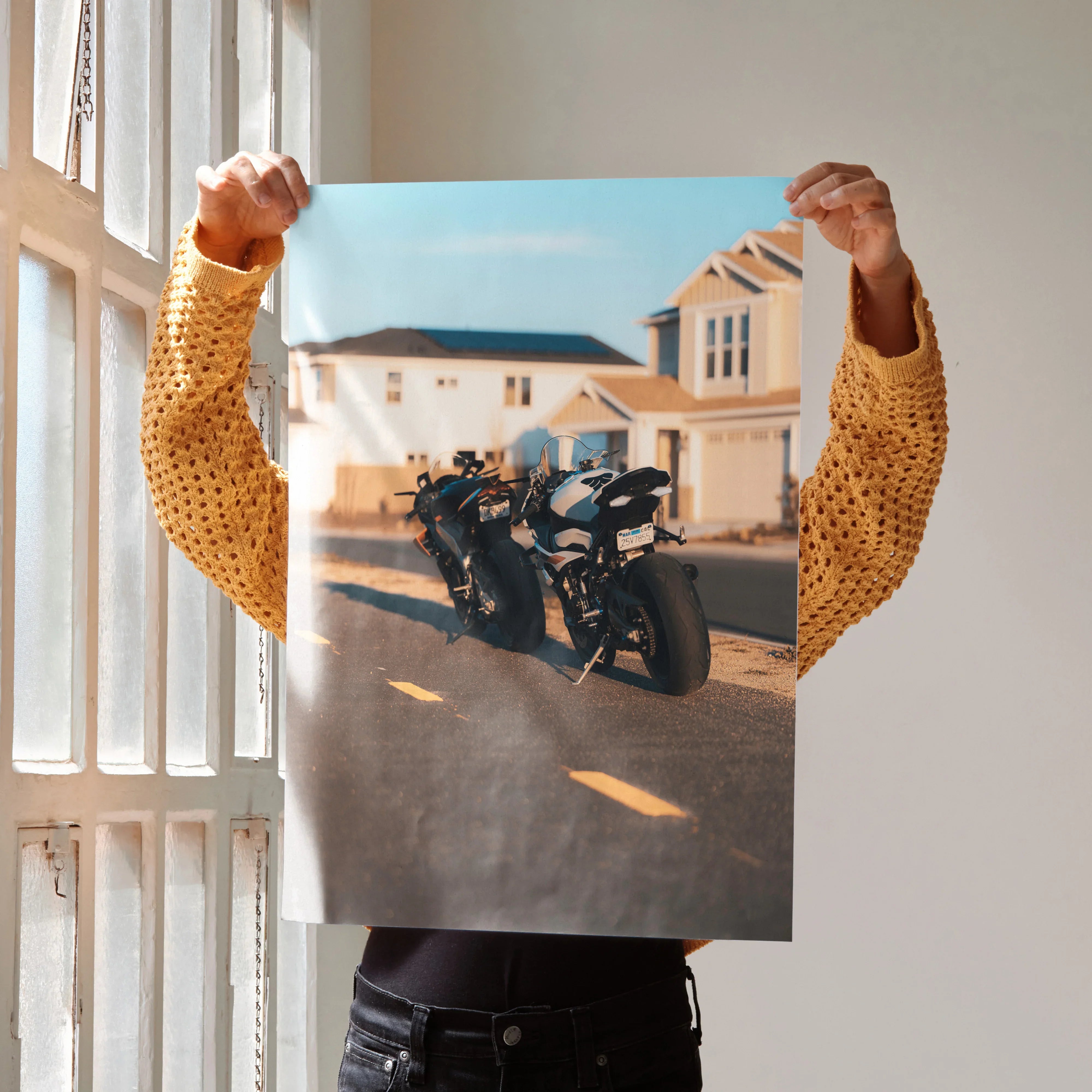 Poster wall art featuring BMW S1000RR and Aprilia RSV4 1100 motorcycles parked on a sunlit suburban street.