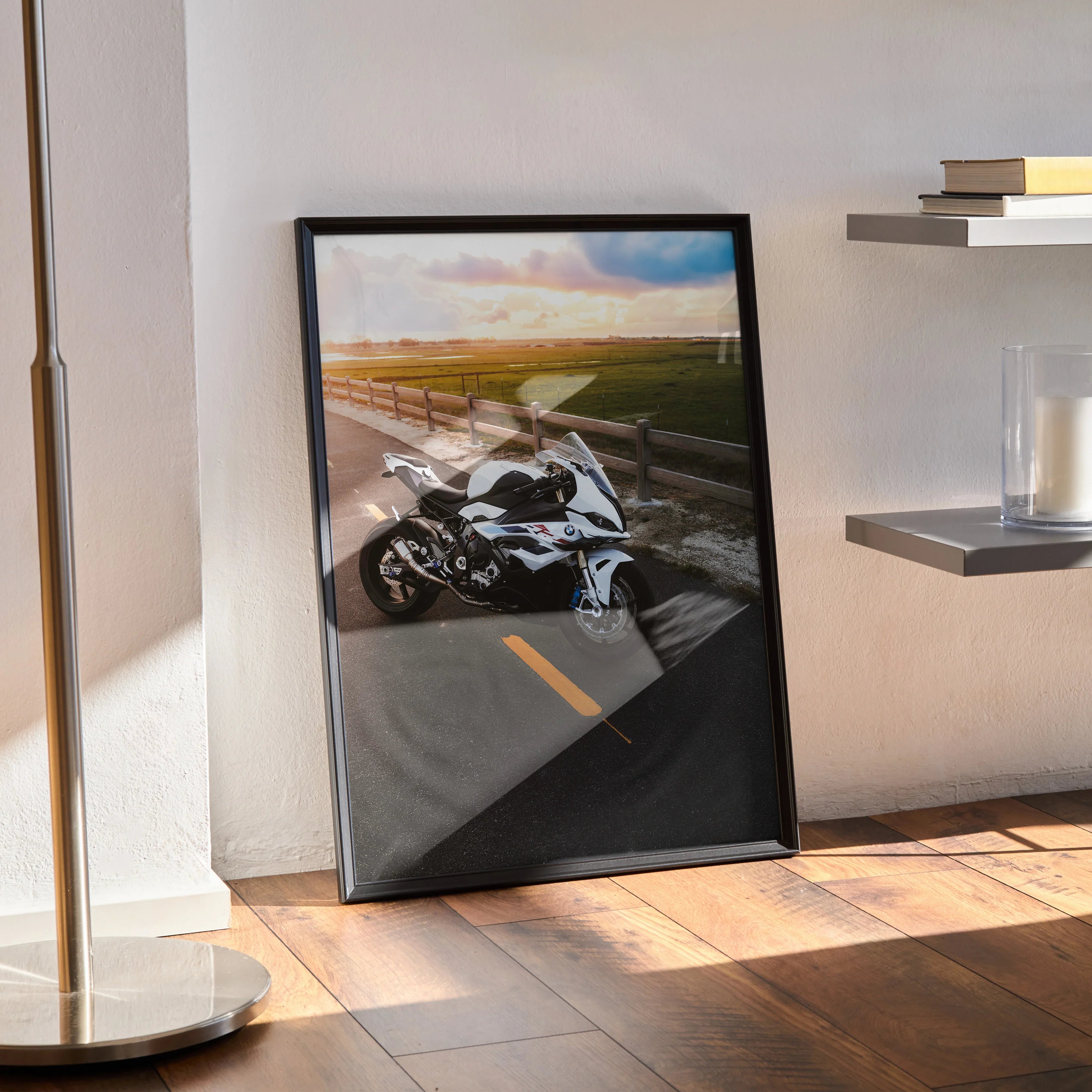 BMW S1000RR motorcycle poster leaning against wall with sunset road scene, black frame wall art.