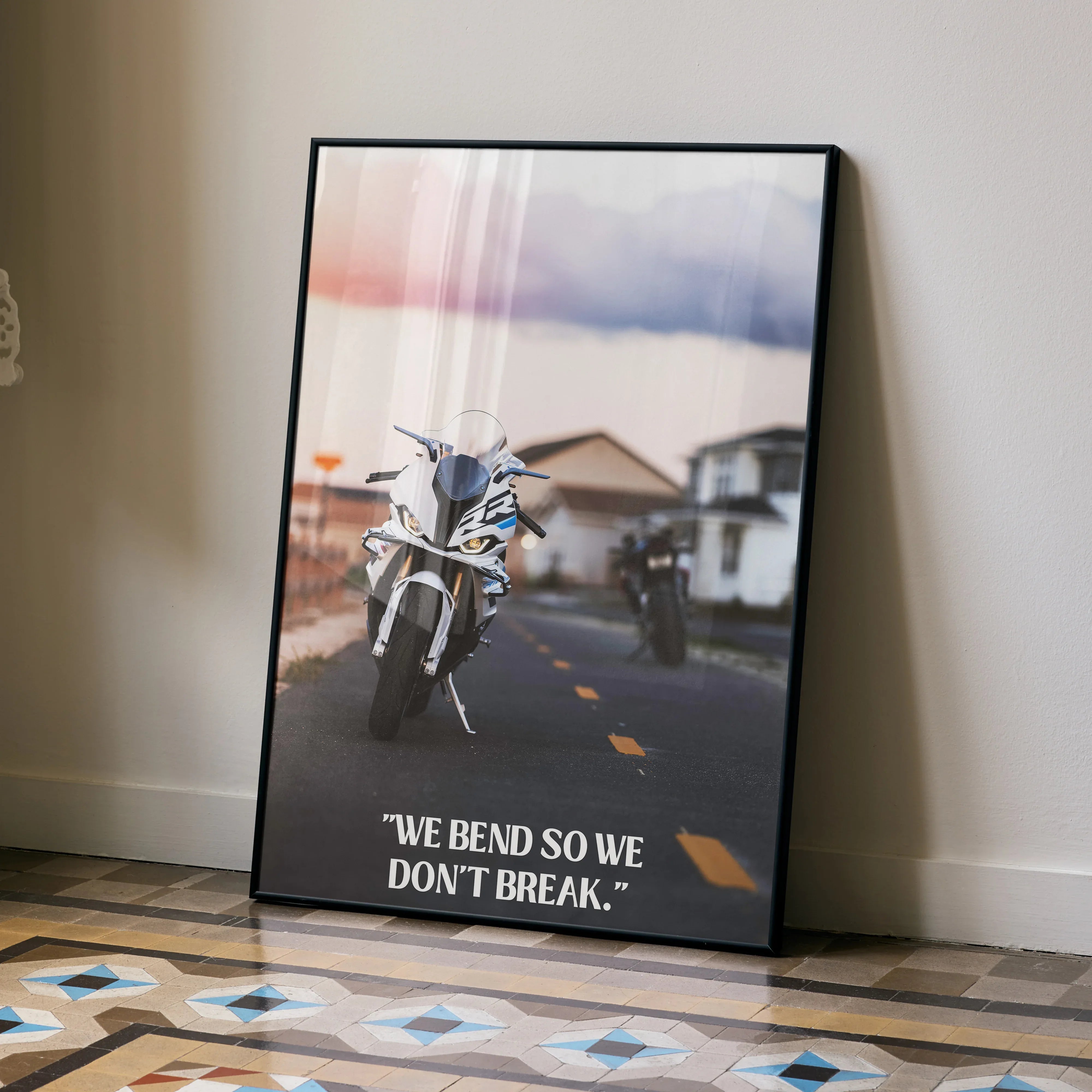 Motivational poster wall art featuring BMW S1000RR motorcycle on road with inspiring quote in black frame.