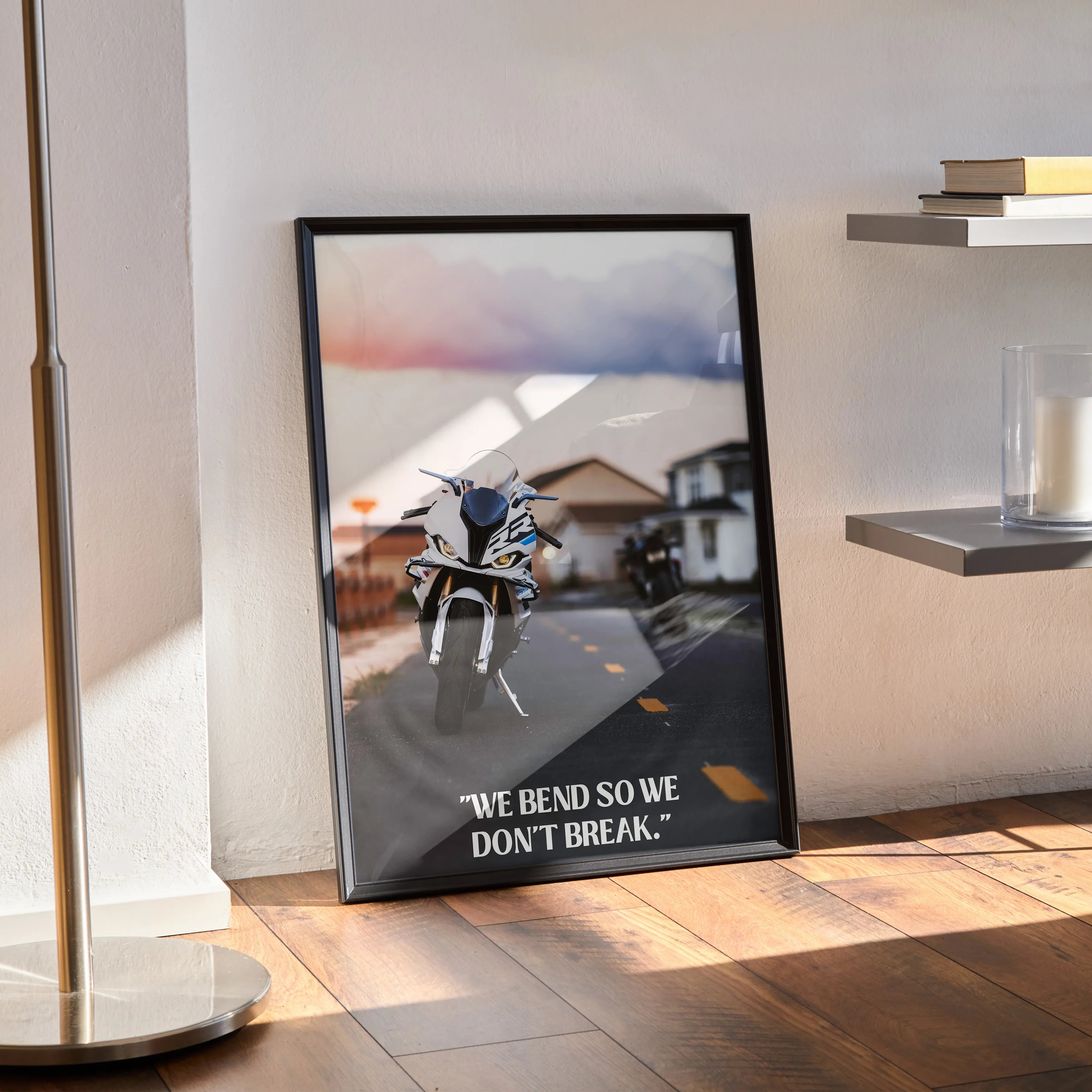 Motivational poster featuring BMW S1000RR motorcycle with inspiring text, framed wall art on wooden floor.