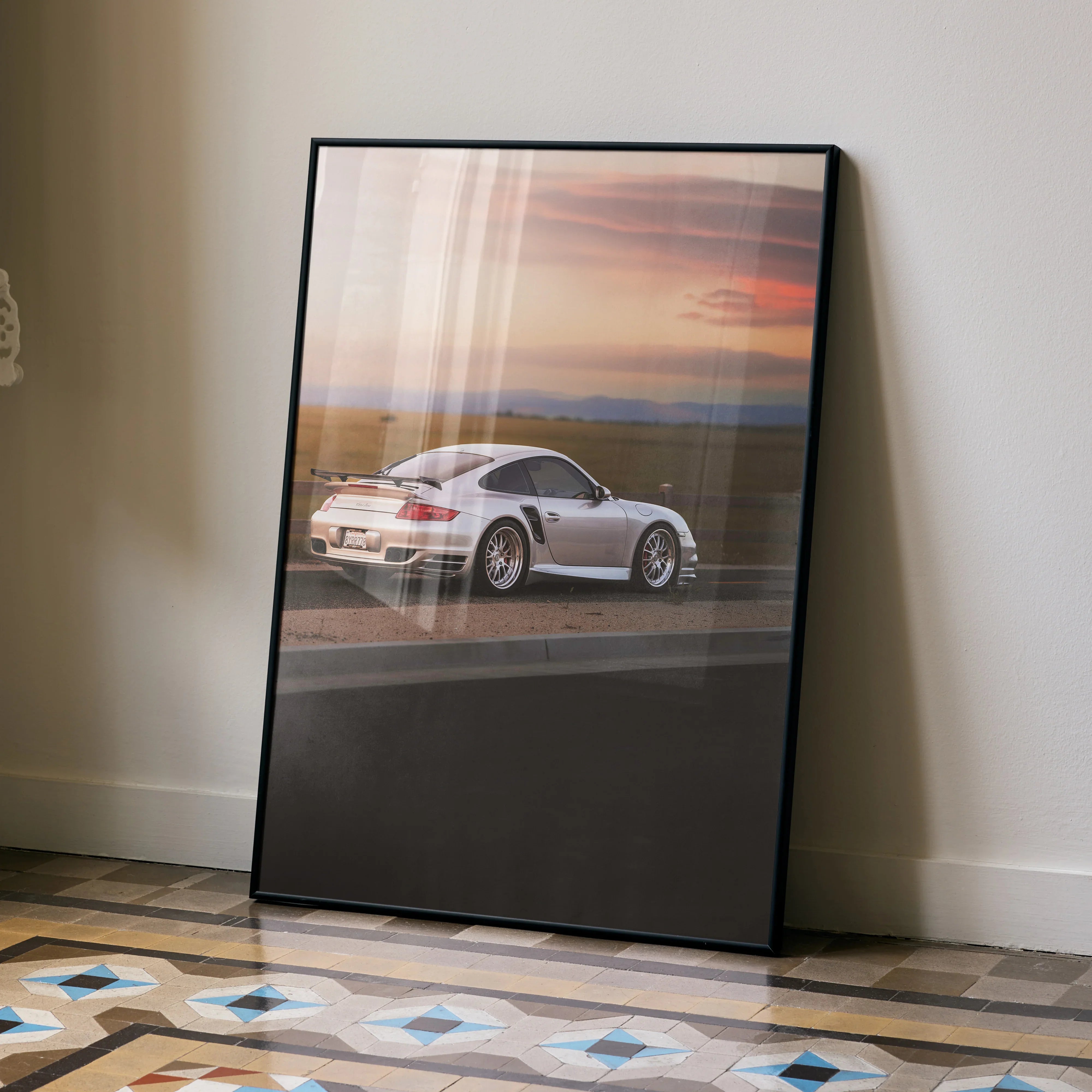 Porsche 911 Turbo poster with sunset backdrop leaning against wall as modern wall art.