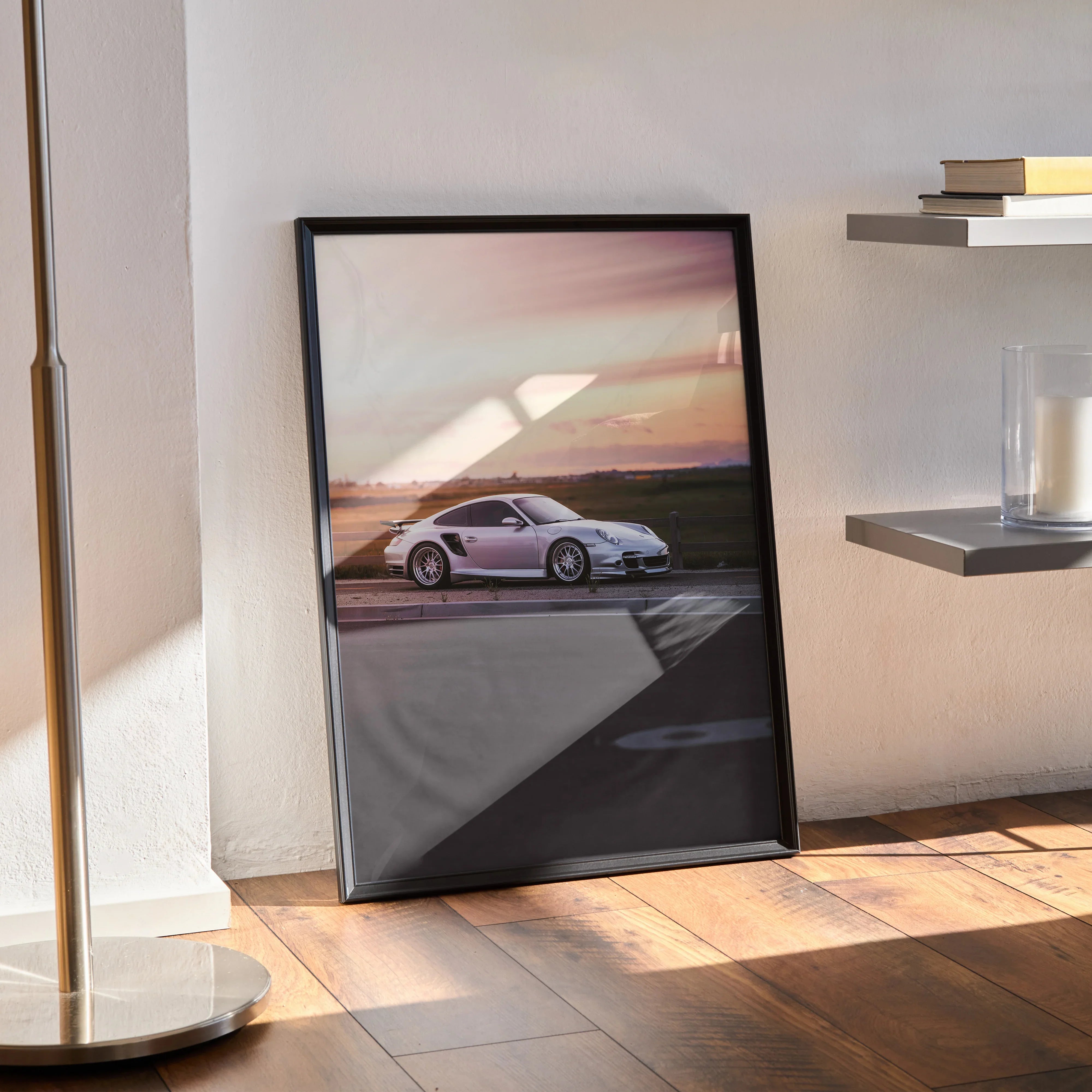 Porsche 911 Turbo at sunset poster framed as wall art leaning against wall on wooden floor.
