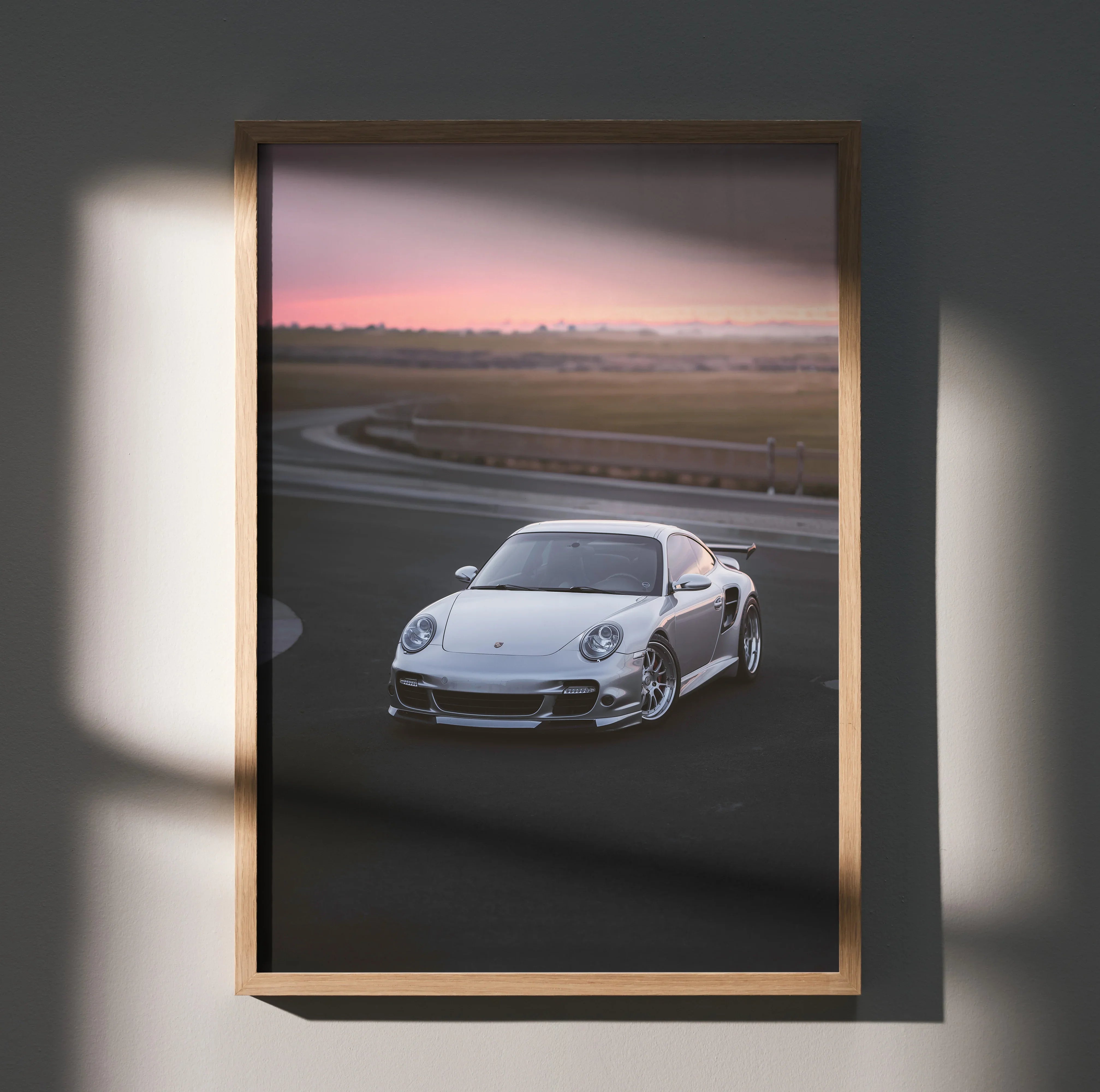 Porsche 911 Turbo driving on racetrack at sunset poster wall art in wooden frame.