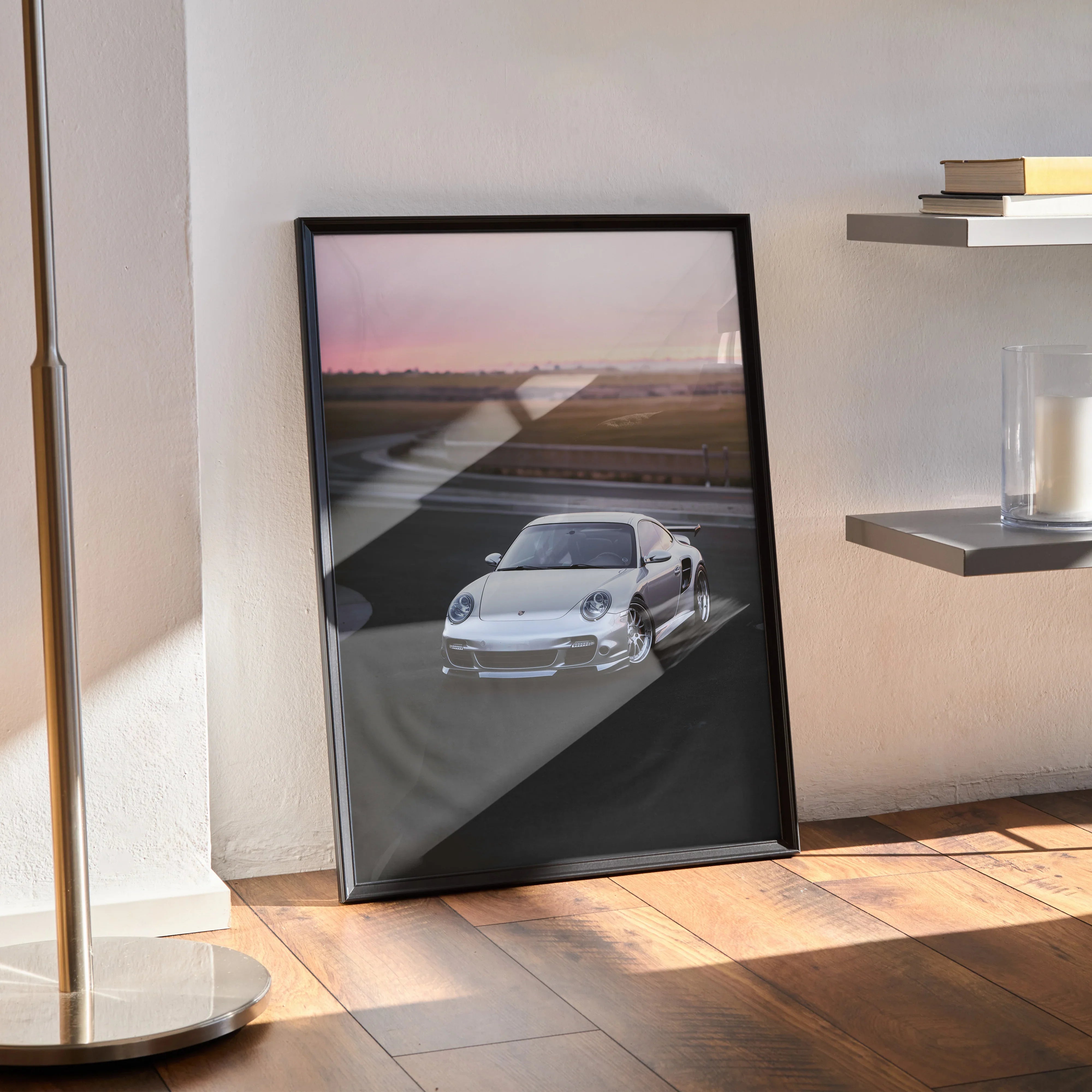 Porsche 911 Turbo poster wall art in black frame showing white car on runway at sunset.