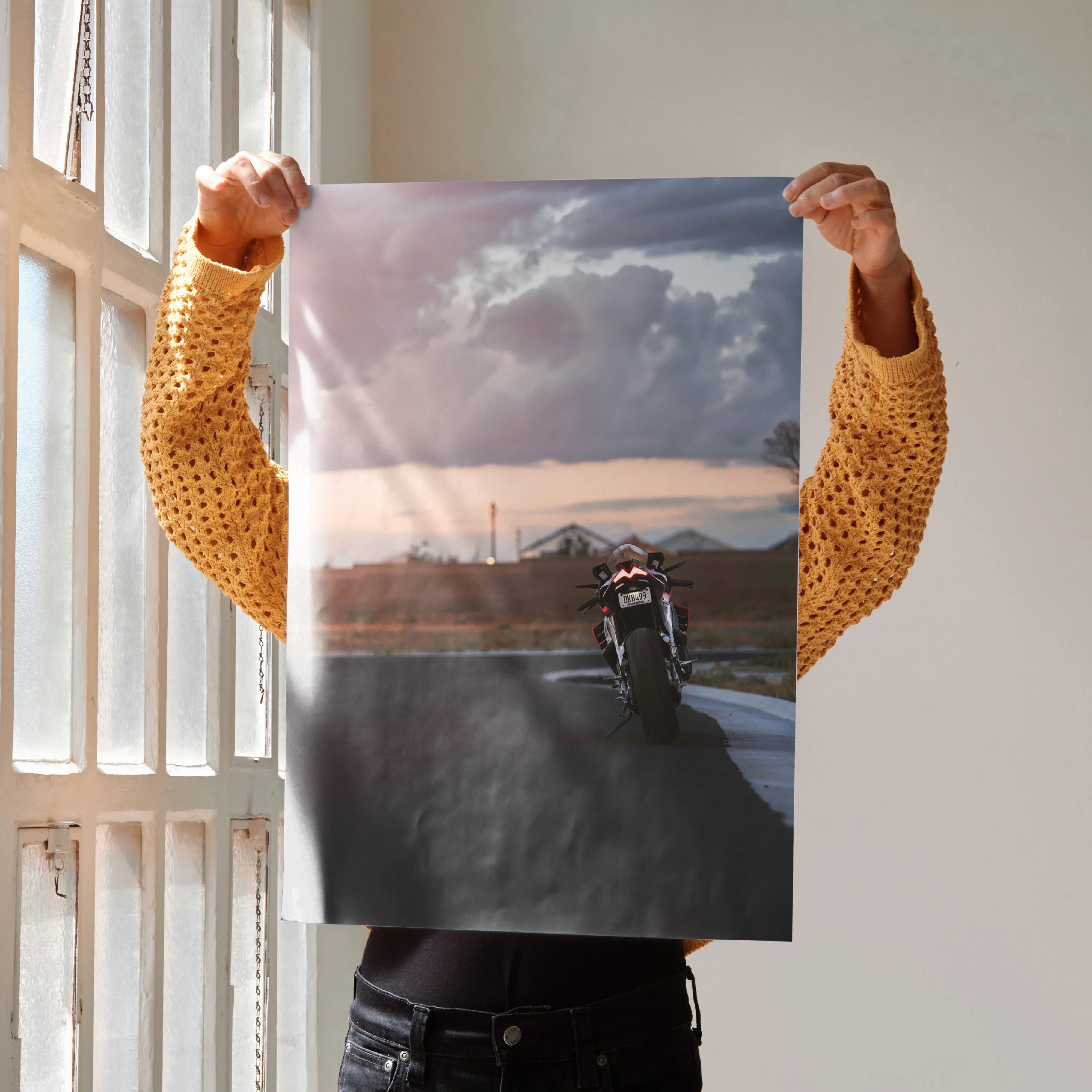 Aprilia RSV4 motorcycle on road at sunset poster wall art with moody sky background.