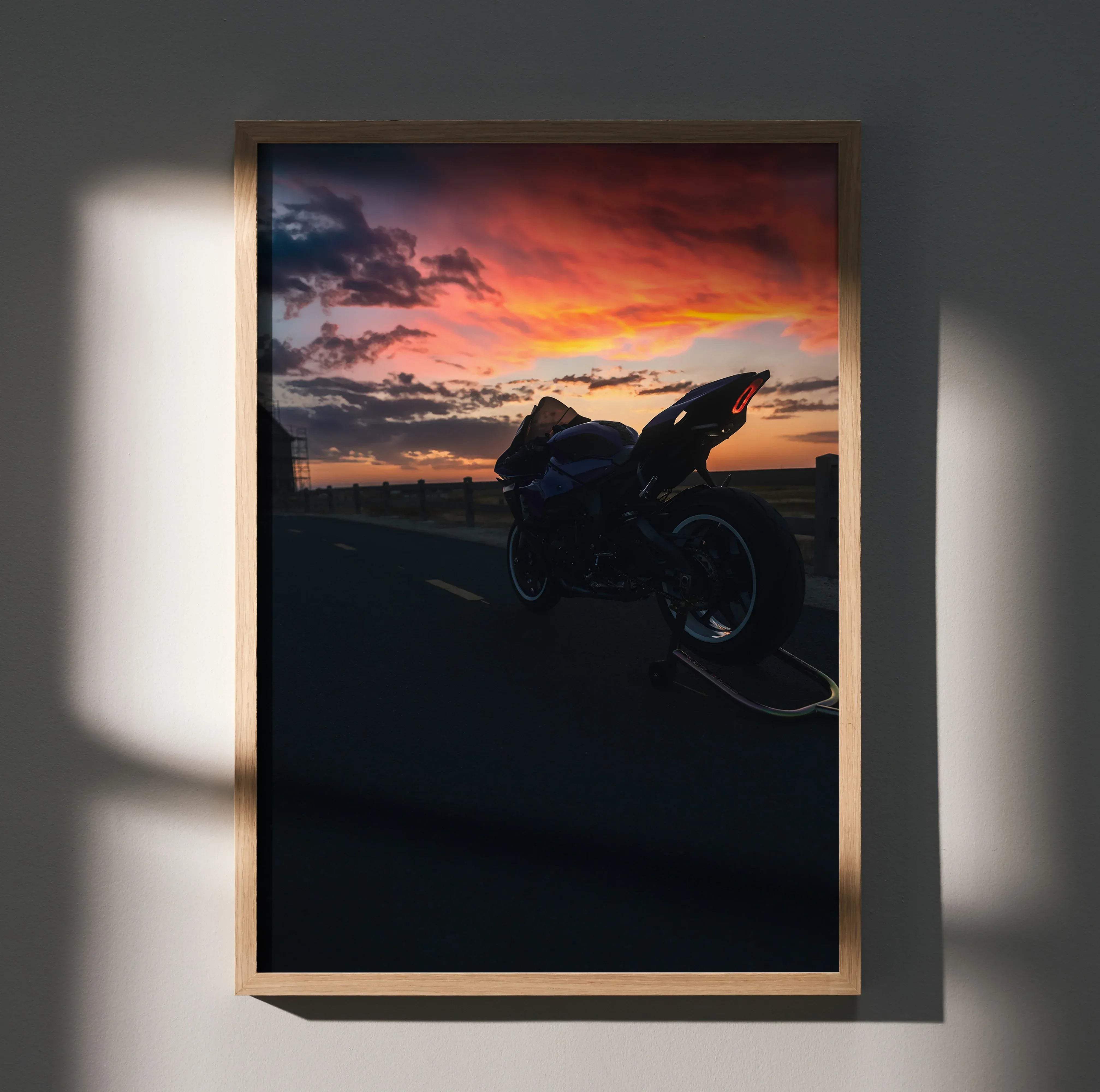A framed Yamaha R1 motorcycle art poster featuring a black silhouette against a vibrant orange red and purple sunset sky