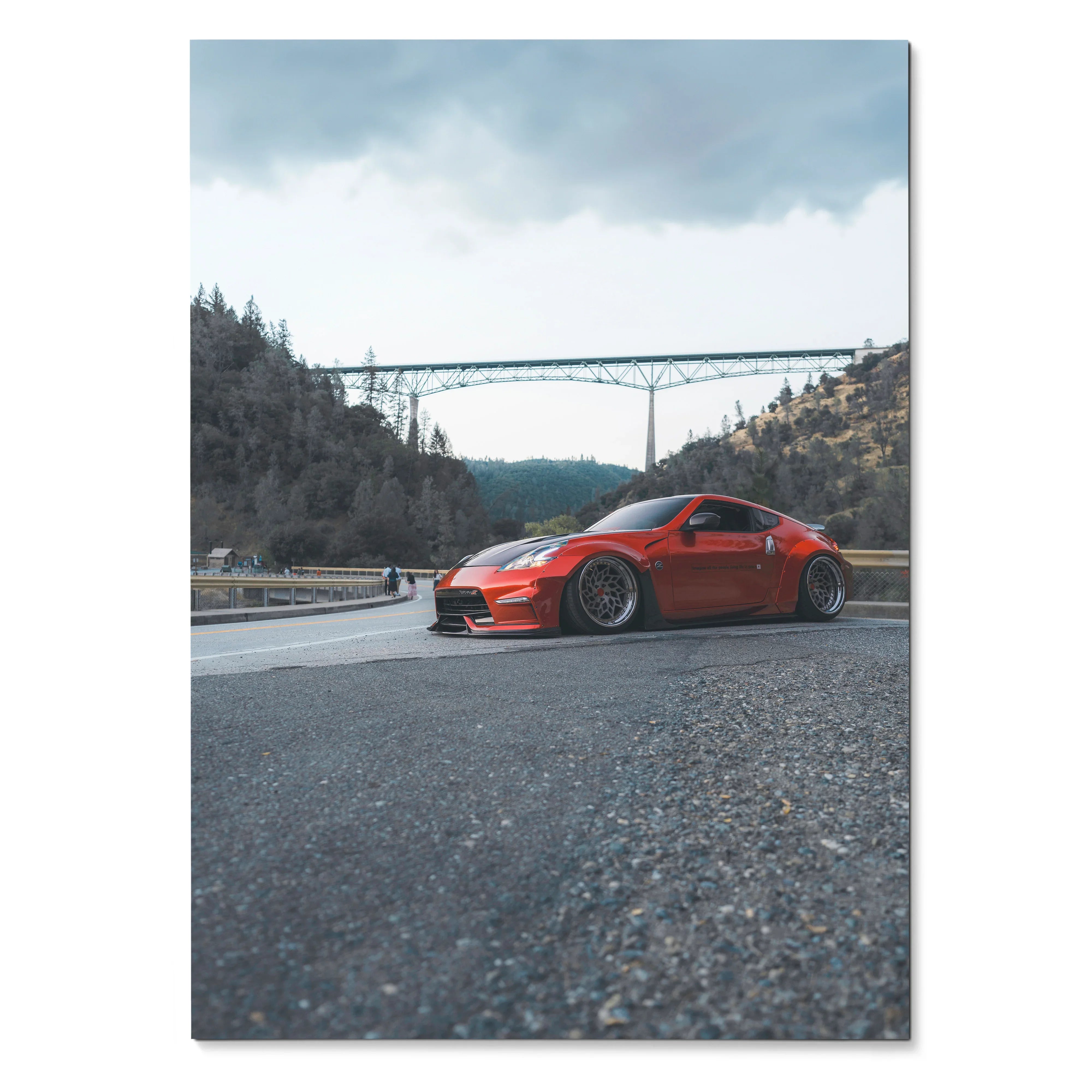 Red Nissan 370Z sports car on road with bridge and hills background poster wall art.