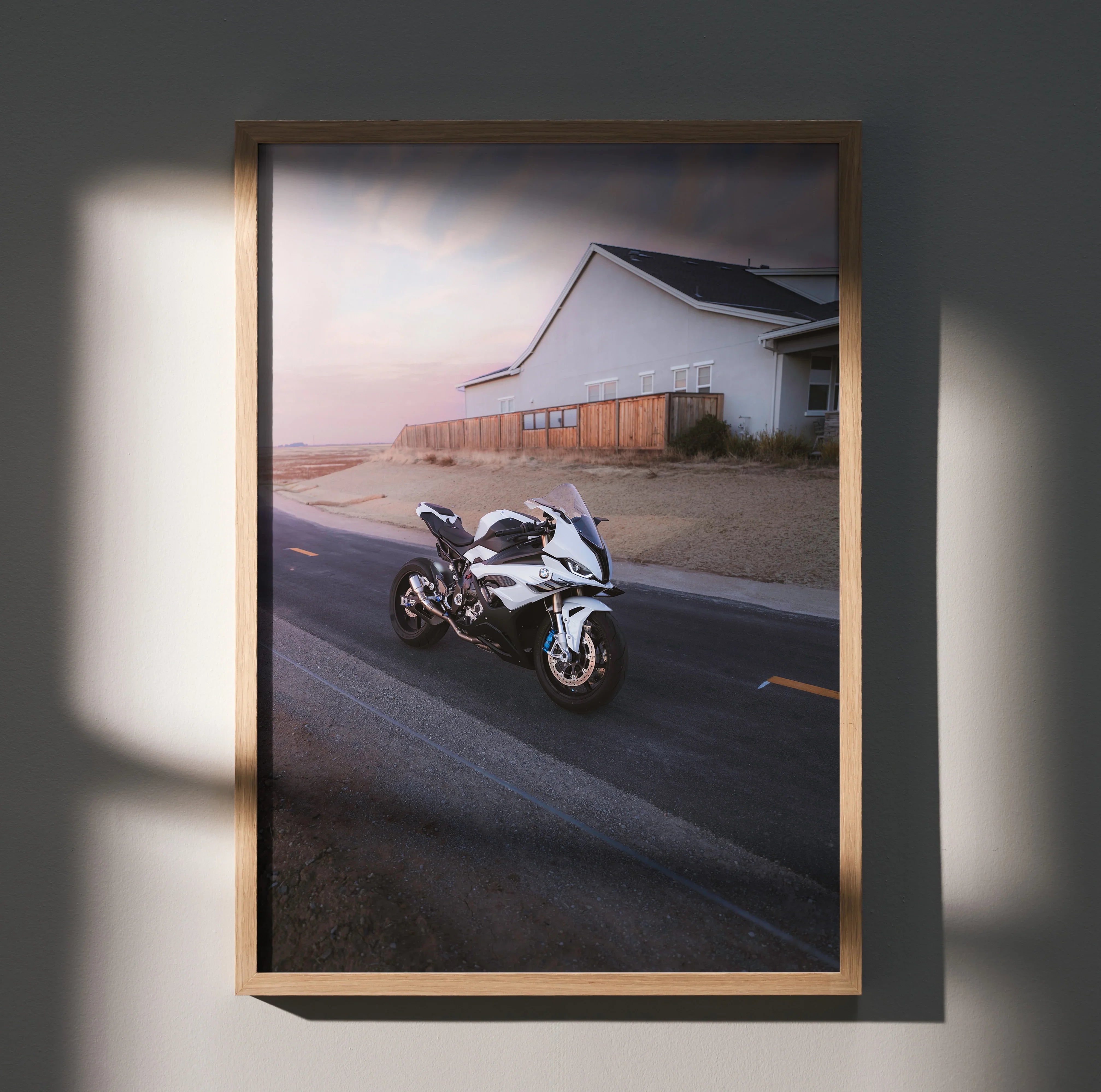 BMW S1000RR motorcycle poster with sunset and modern architecture, sleek wall art in wooden frame.