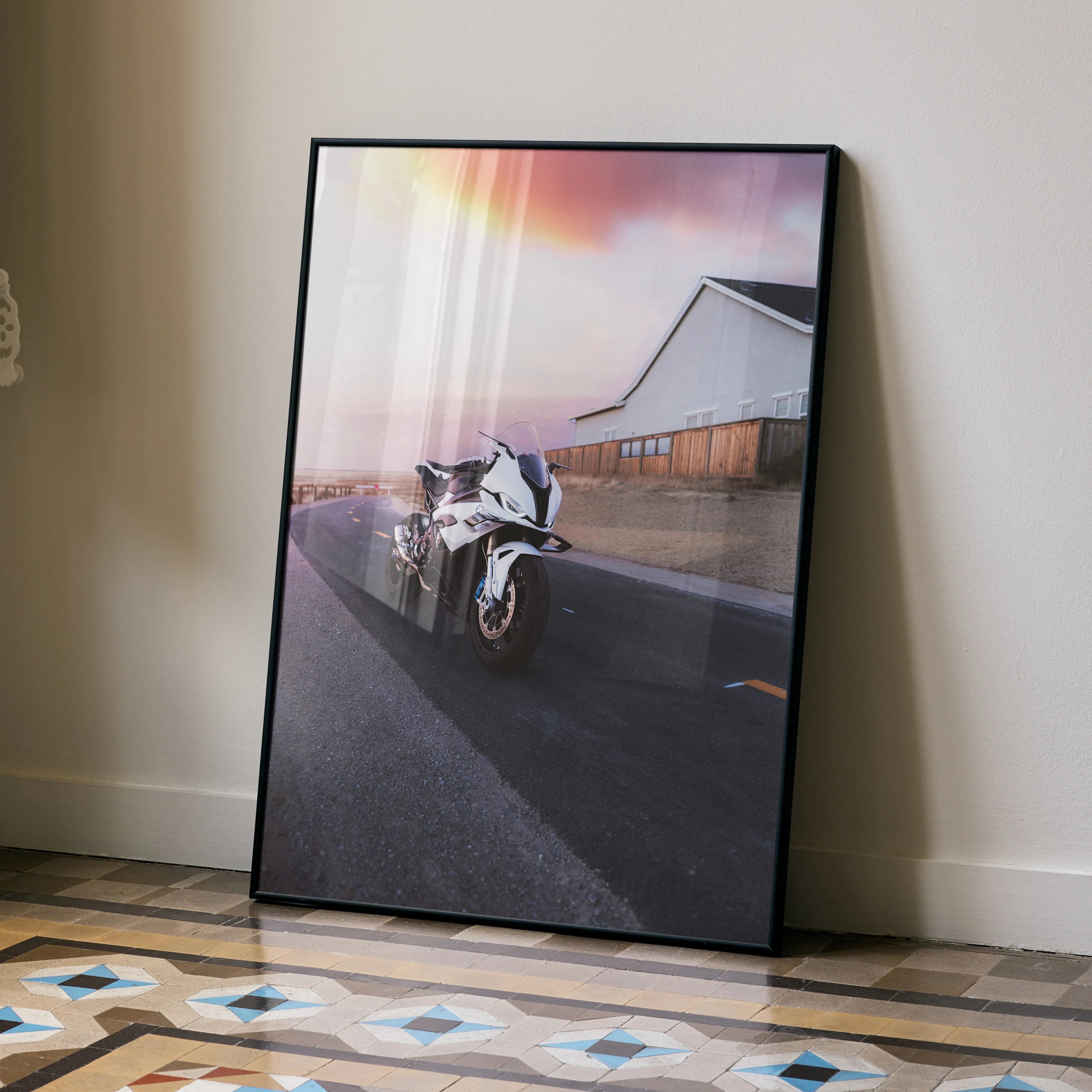 BMW S1000RR motorcycle poster leaning against wall with sunset and modern building background wall art.