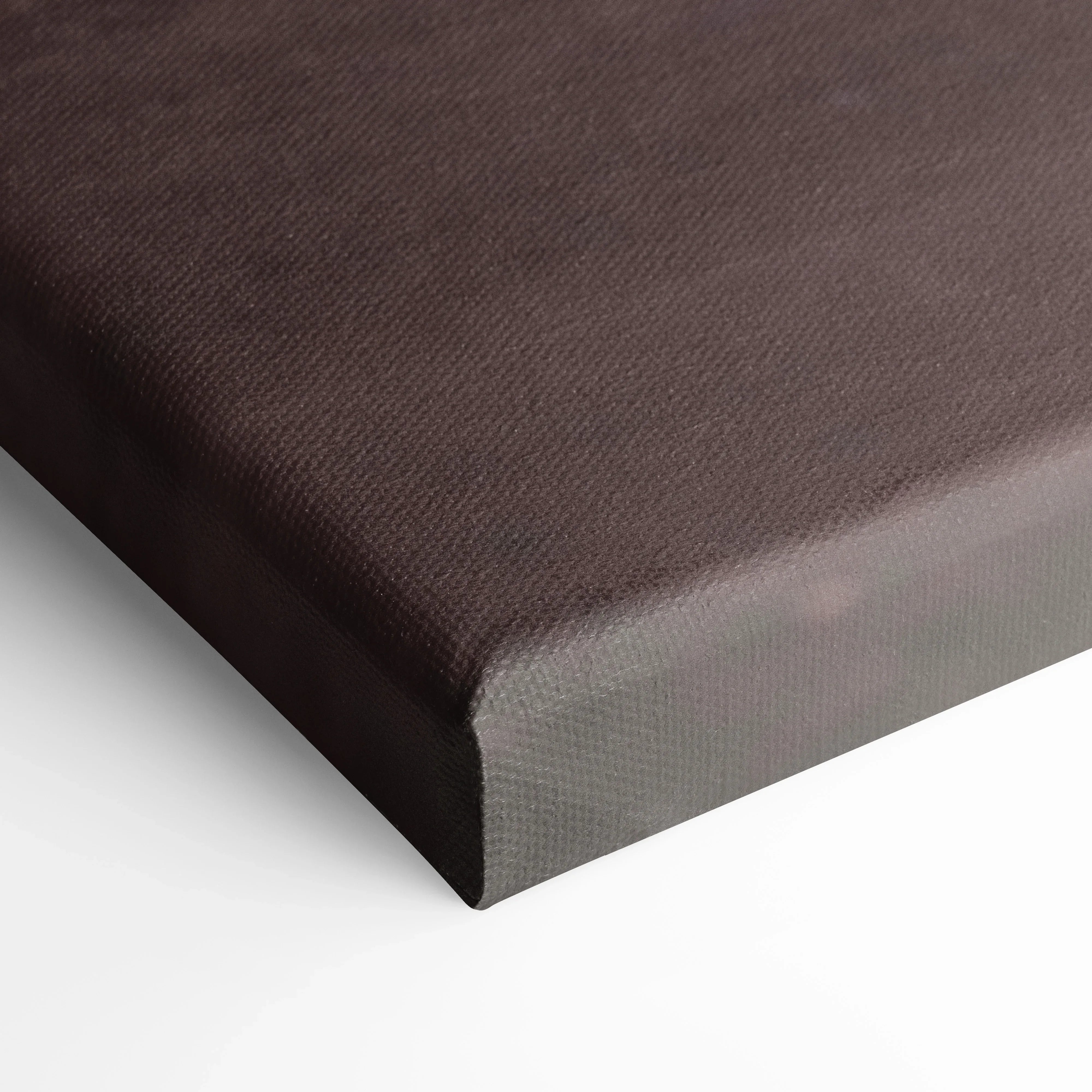 Close-up of black canvas wall art with textured fabric edge wrapped around wooden frame.