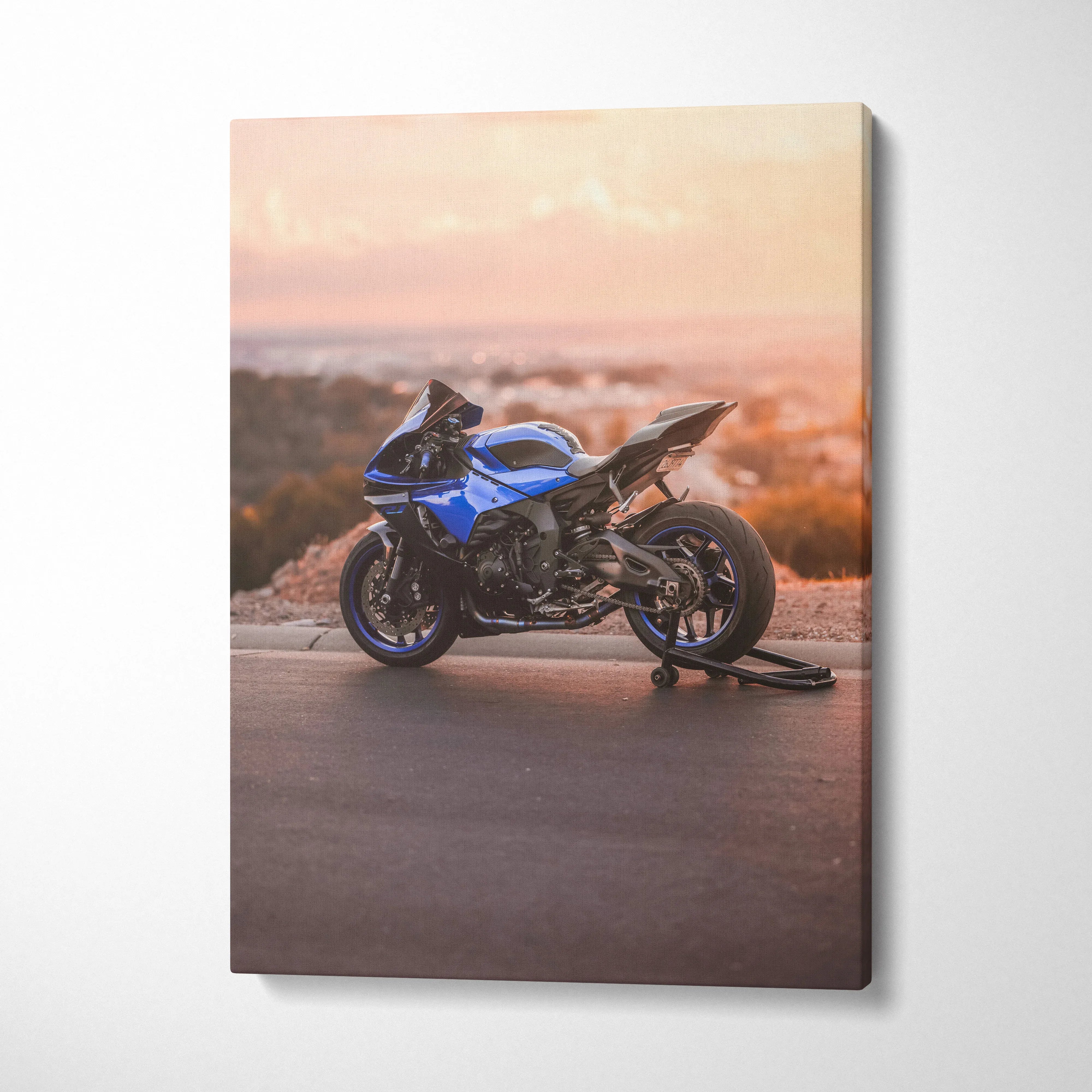 Blue Yamaha R1 motorcycle at sunset on canvas wall art with warm orange sky background.
