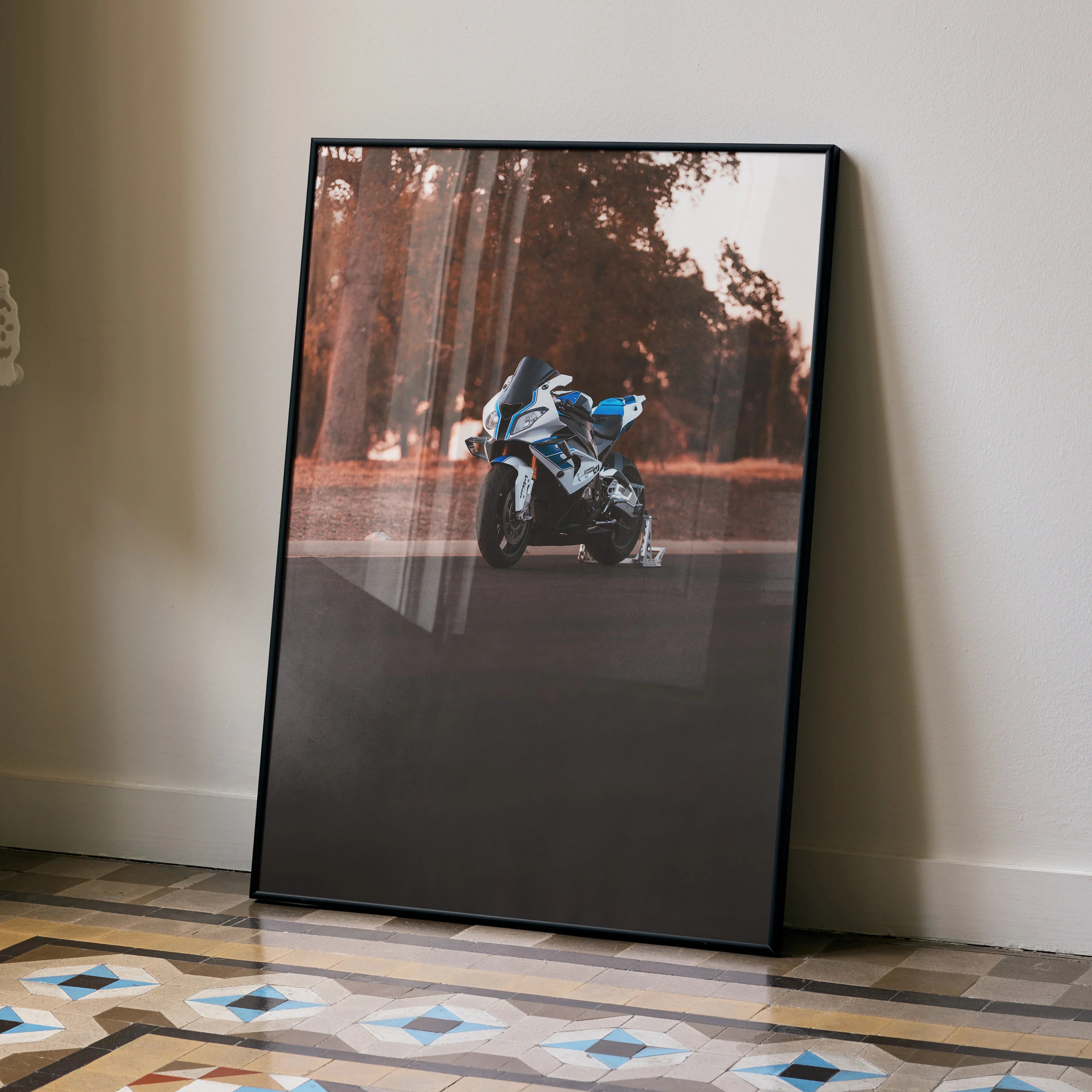 BMW S1000RR HP4 motorcycle wall art poster leaning against beige wall with geometric floor tiles.