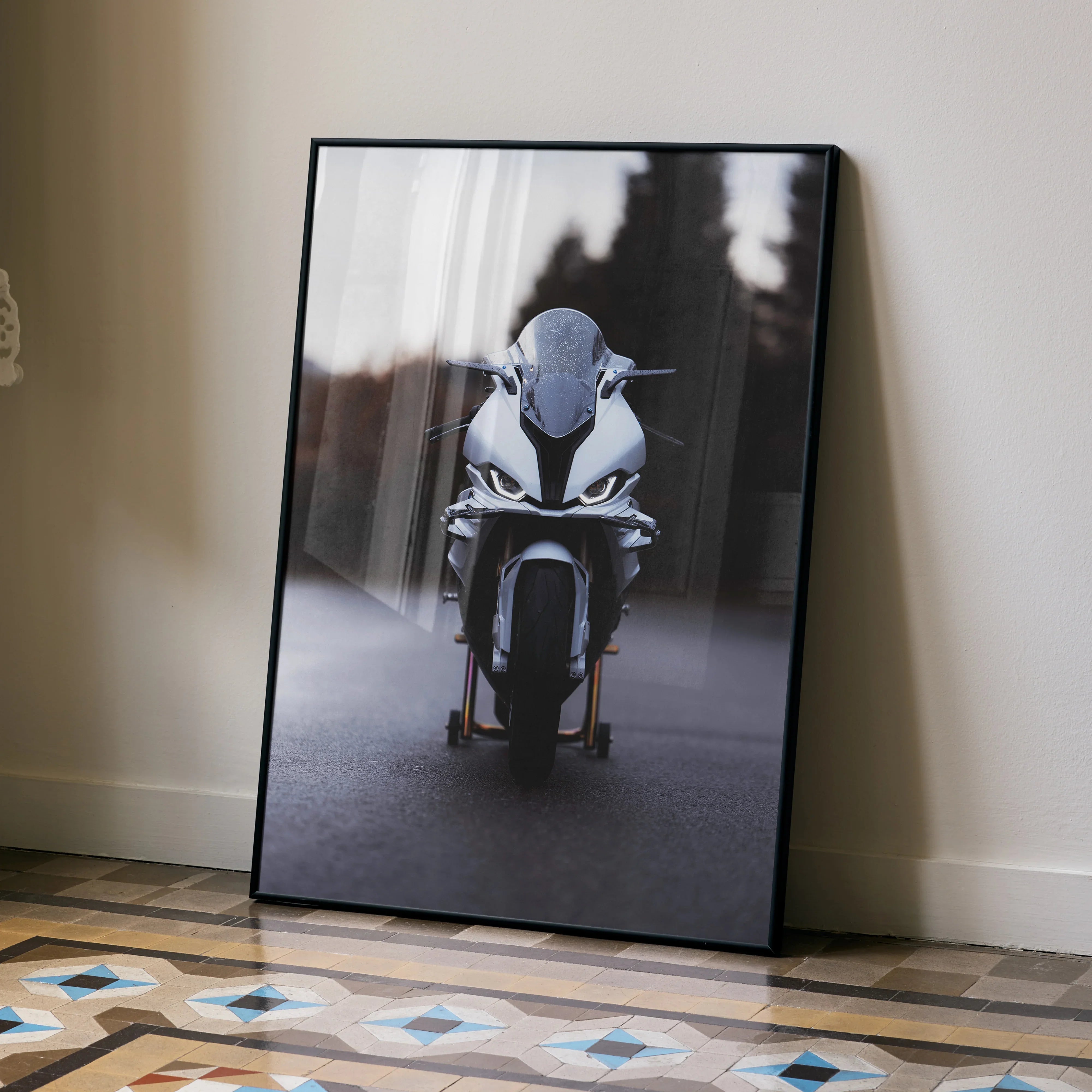 BMW S1000RR motorcycle front view poster wall art in black frame leaning on floor.