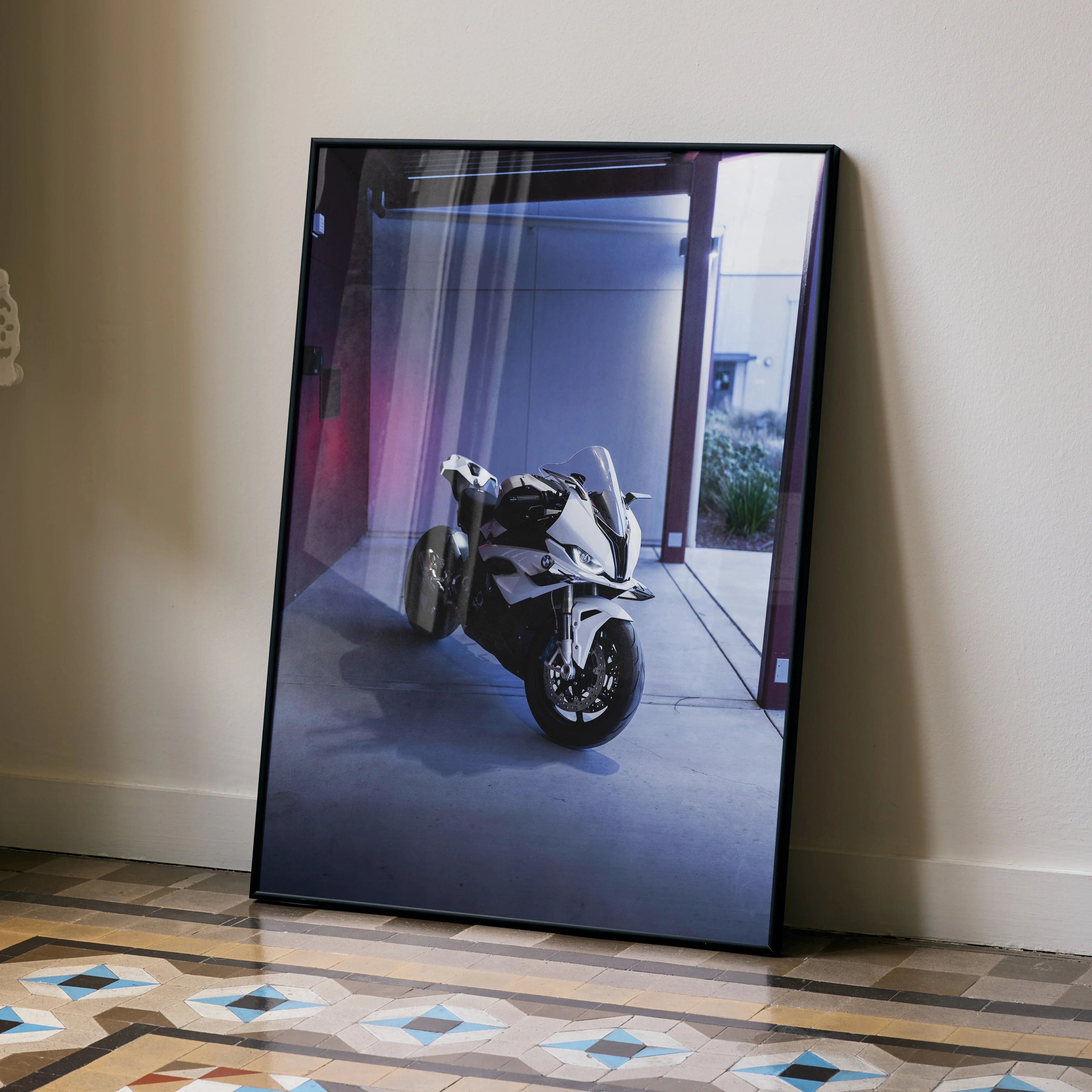 BMW S1000RR motorcycle poster in black frame leaning against wall, modern wall art.