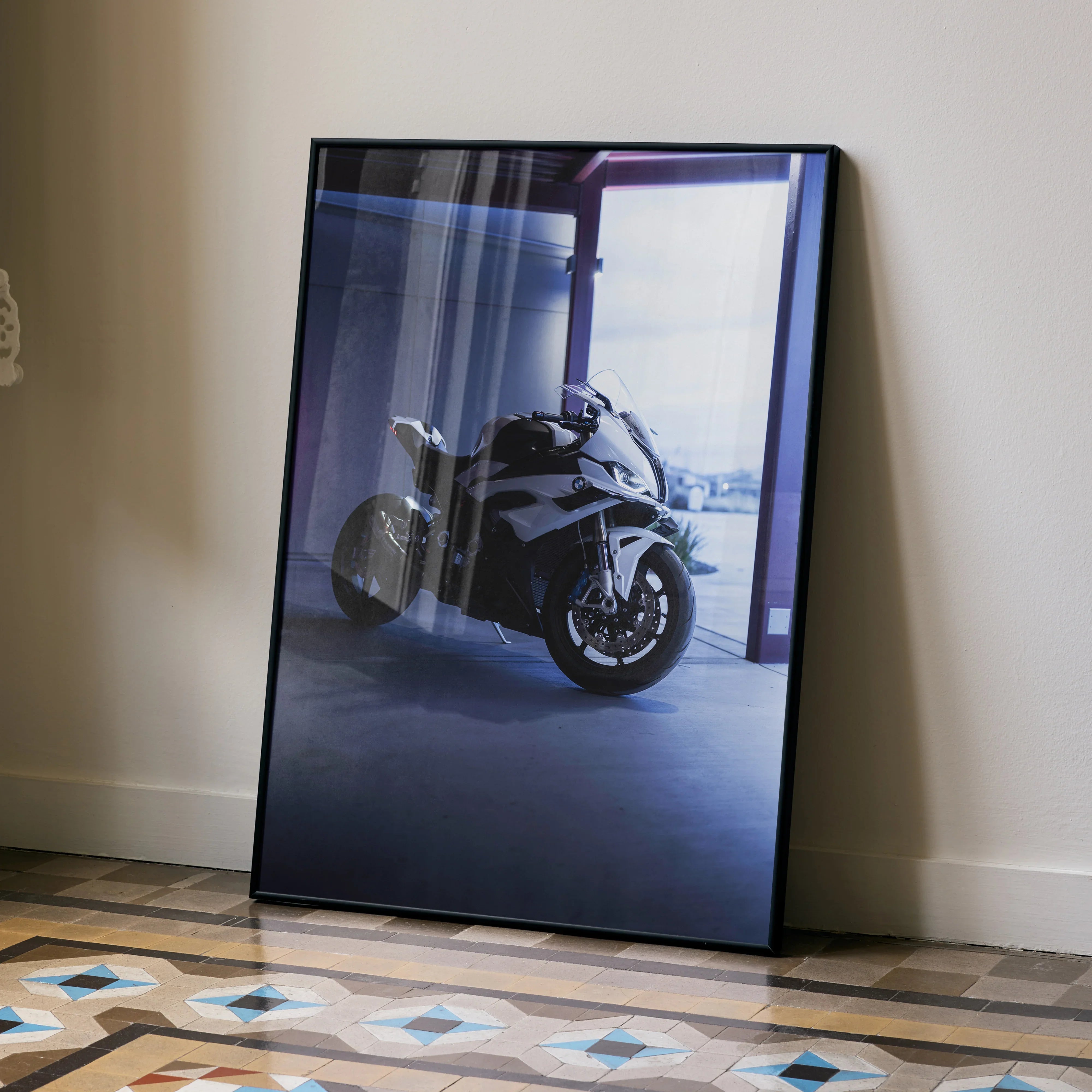 BMW S1000RR motorcycle poster leaning against wall, modern wall art with dark tones and blue lighting.