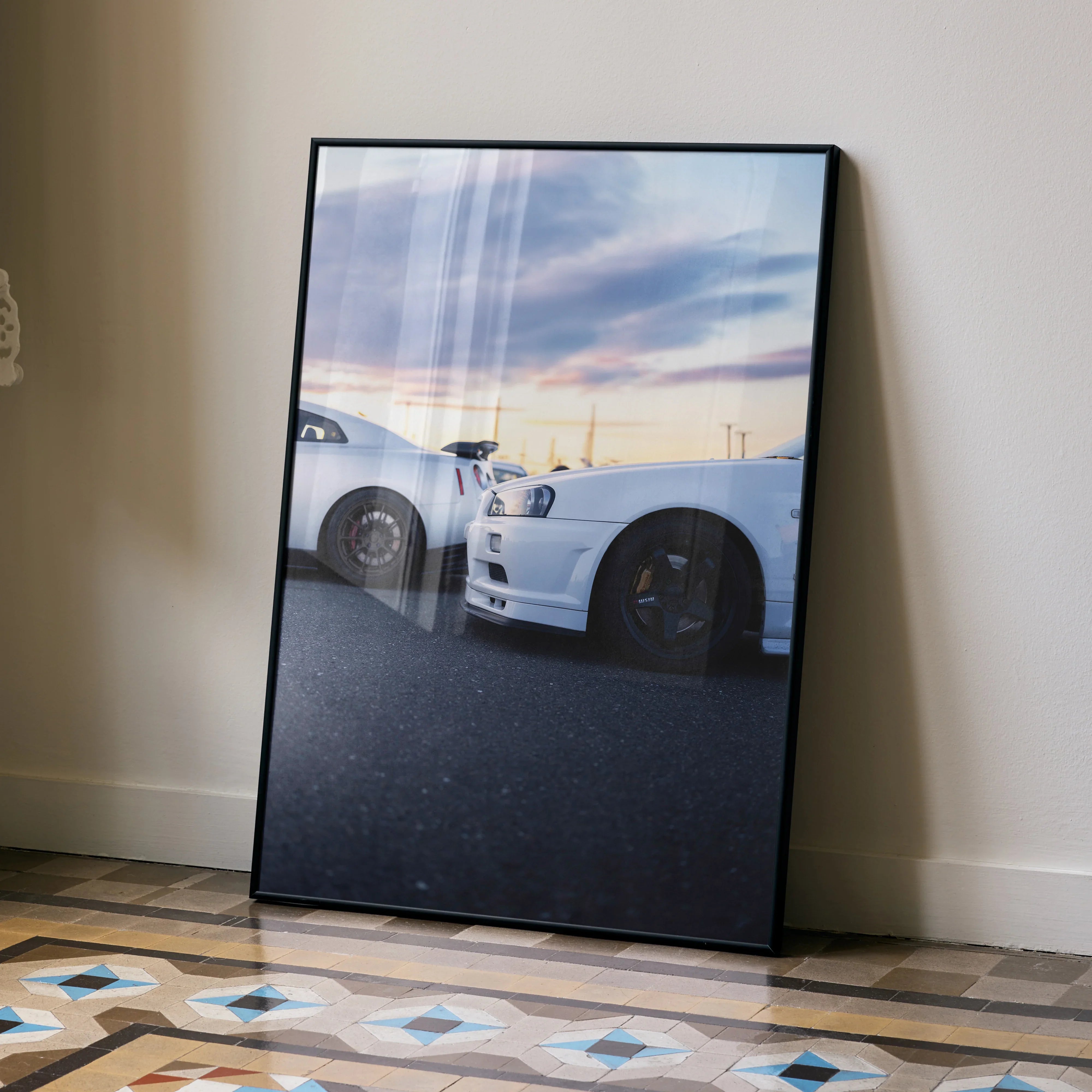 Nissan R34 GTR Skyline parked side by side under a colorful sky poster wall art in black frame.