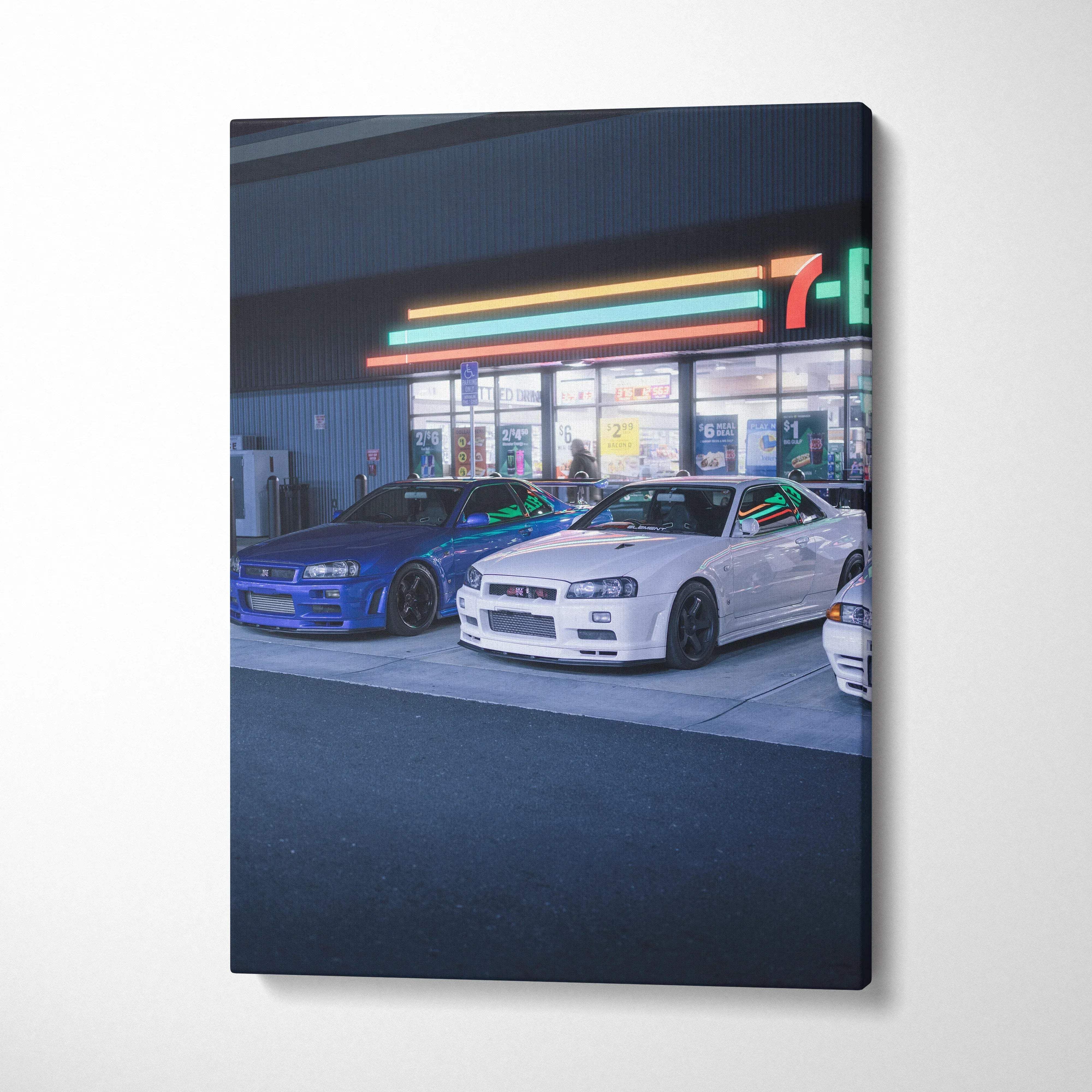 Vertical canvas art featuring white and blue Nissan GTR R34 Skyline cars parked outside a 7-Eleven at night, wall art with.