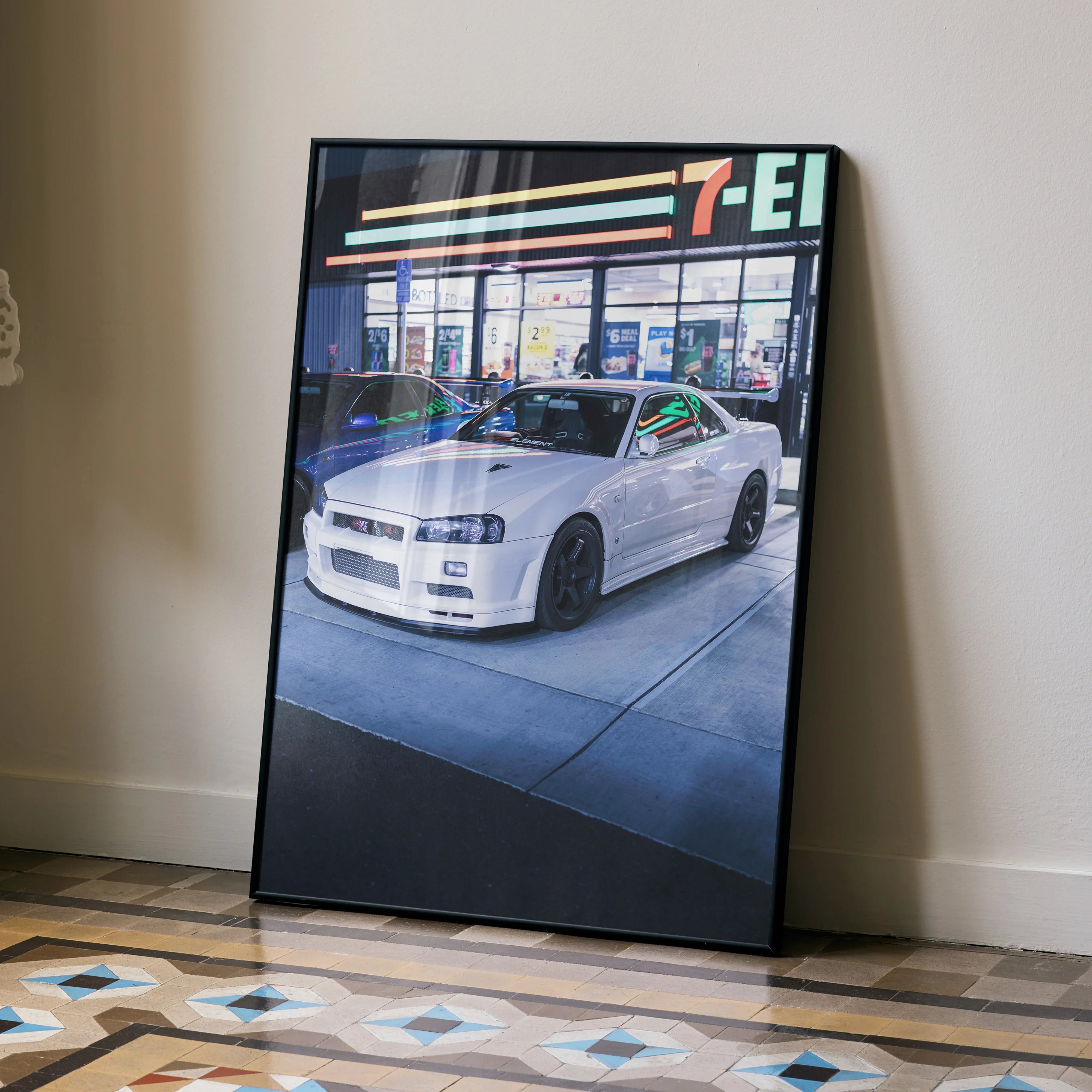 Nissan GTR R34 Skyline poster with white car in front of 7-Eleven, automotive wall art.