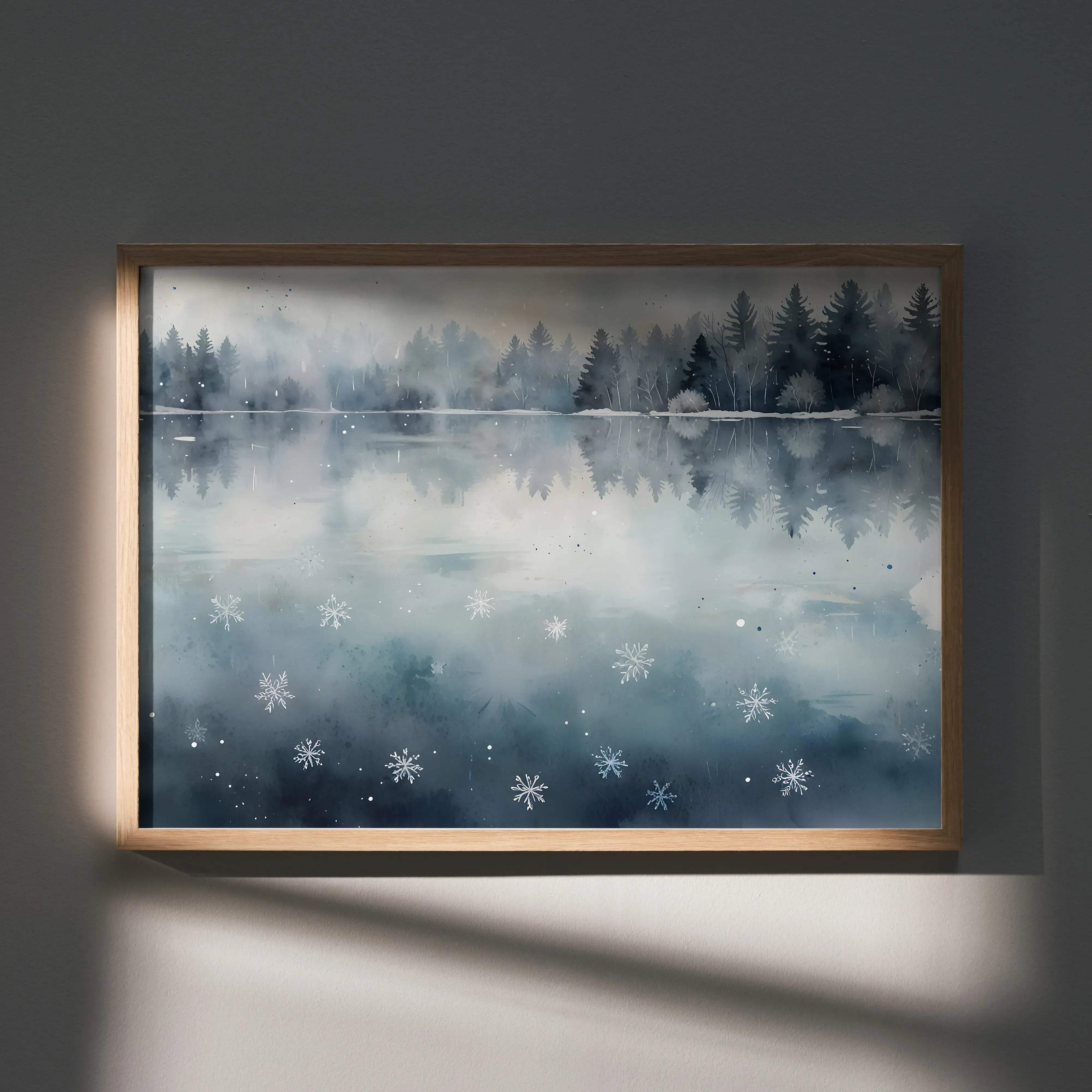 A framed watercolor painting of a misty lake with snowflakes in a light wood frame for serene winter decor