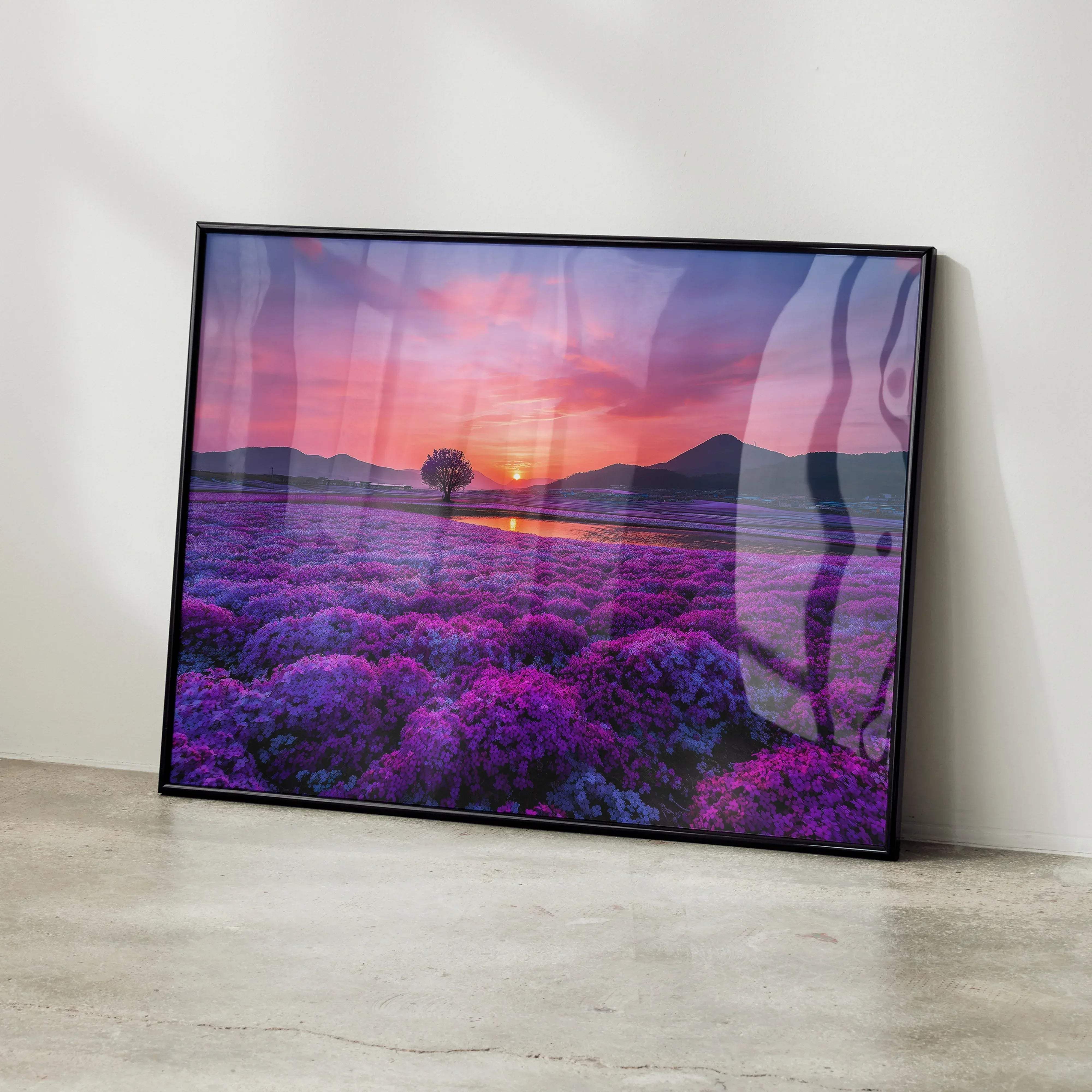 A framed canvas print of a vibrant purple lavender field at sunset with mountains and tree in a black frame