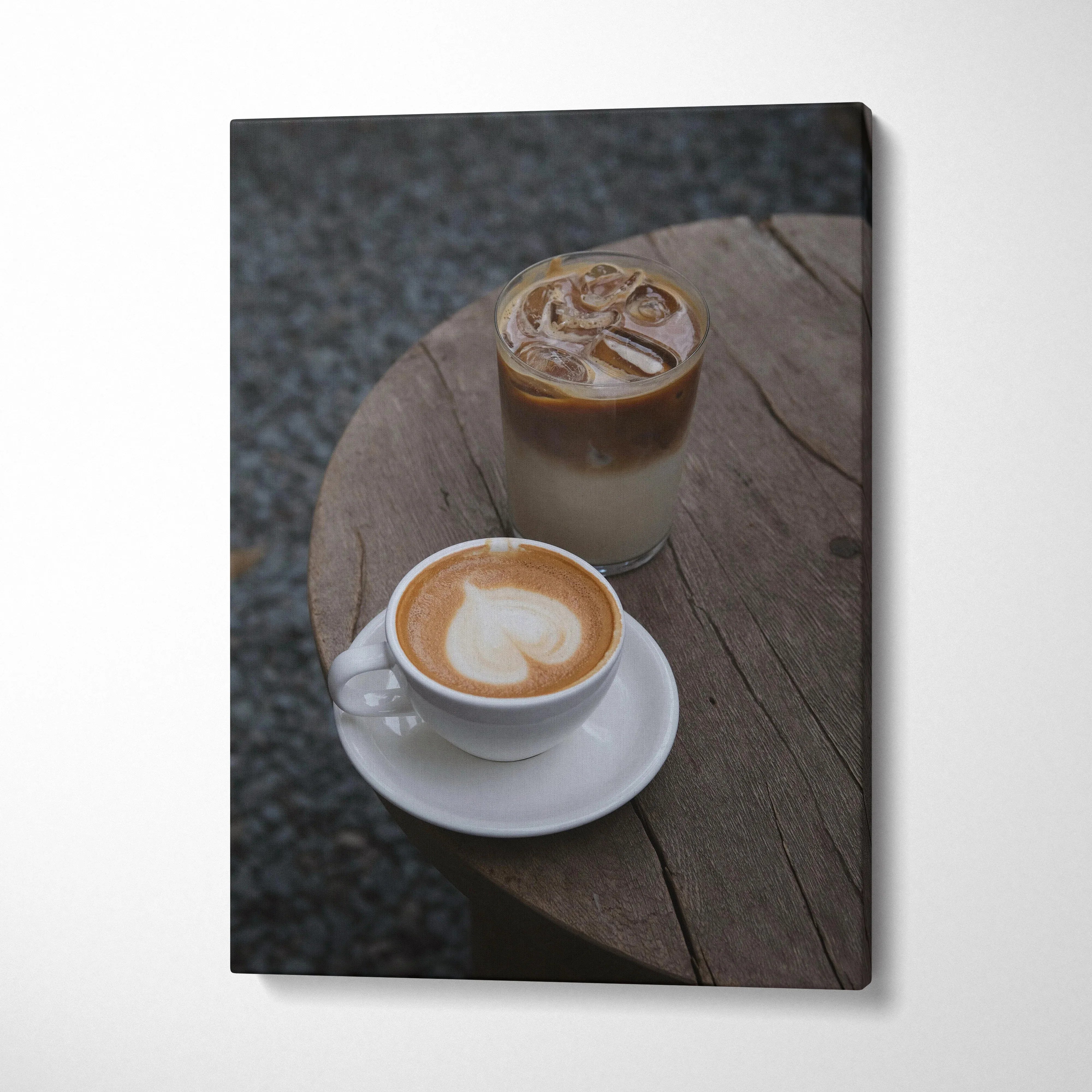 Vertical canvas wall art featuring digital art of two coffee drinks on a rustic wooden table.
