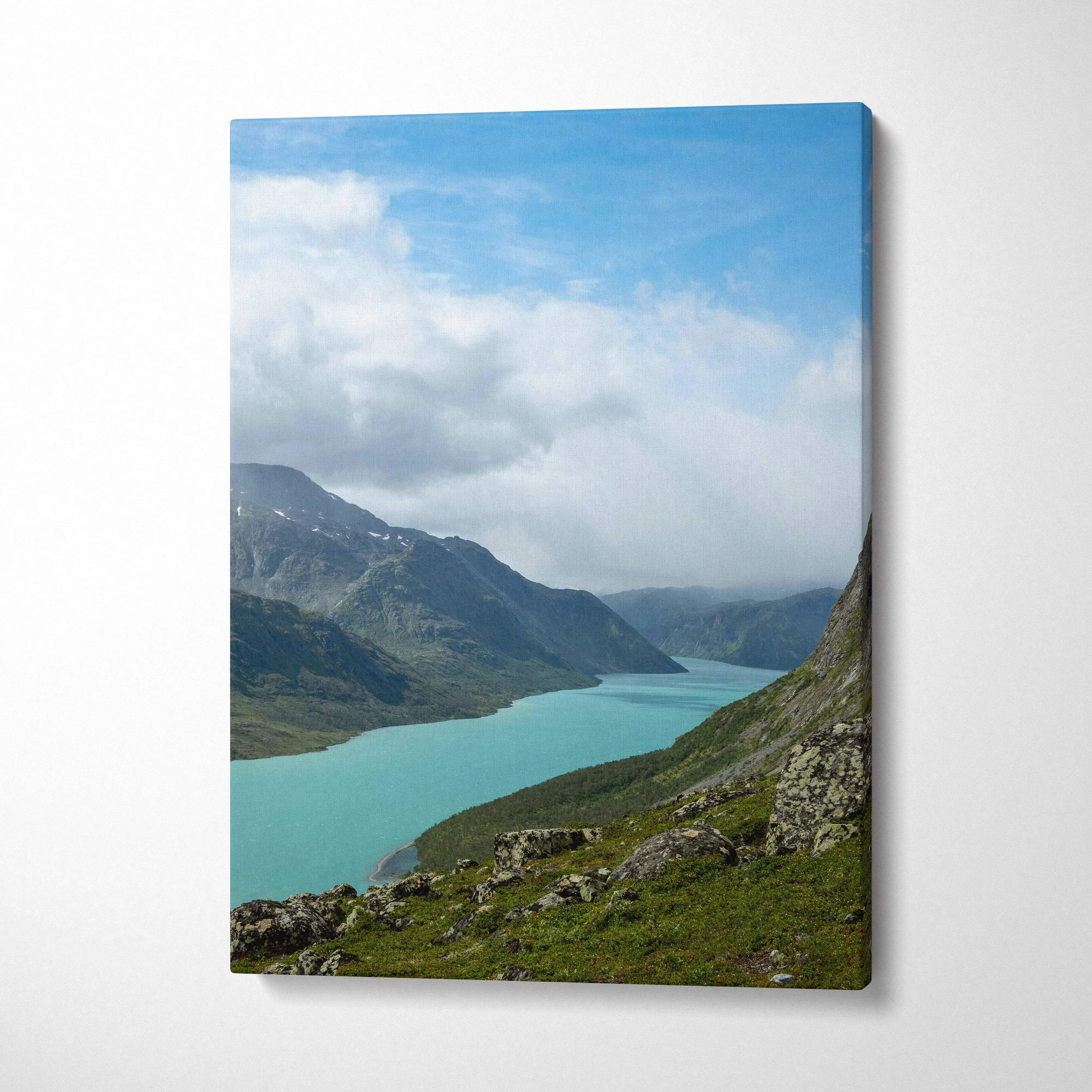 Mountain landscape with turquoise lake and cloudy sky canvas wall art in vertical format.