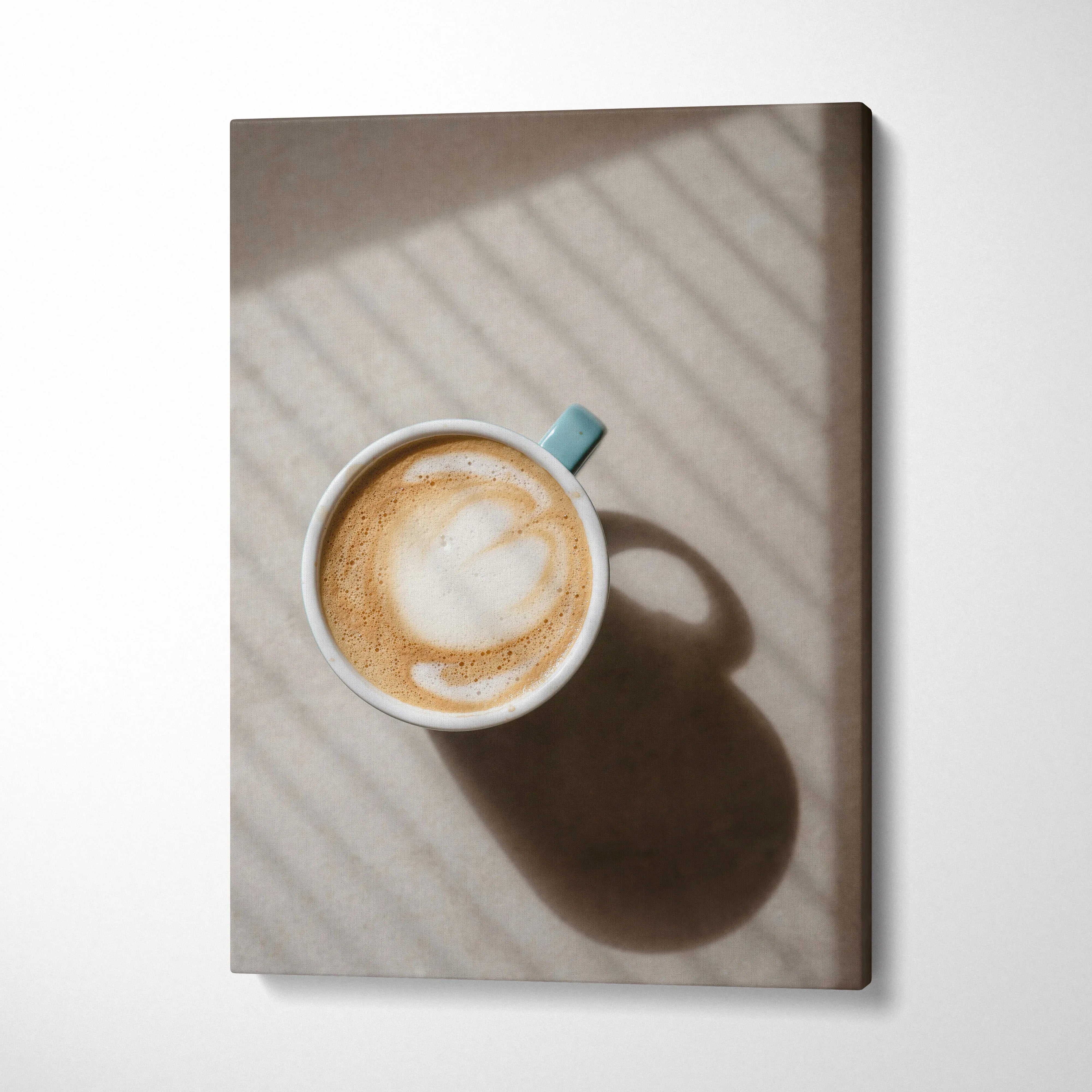 Canvas wall art featuring overhead view of coffee cup casting soft shadow on neutral background.