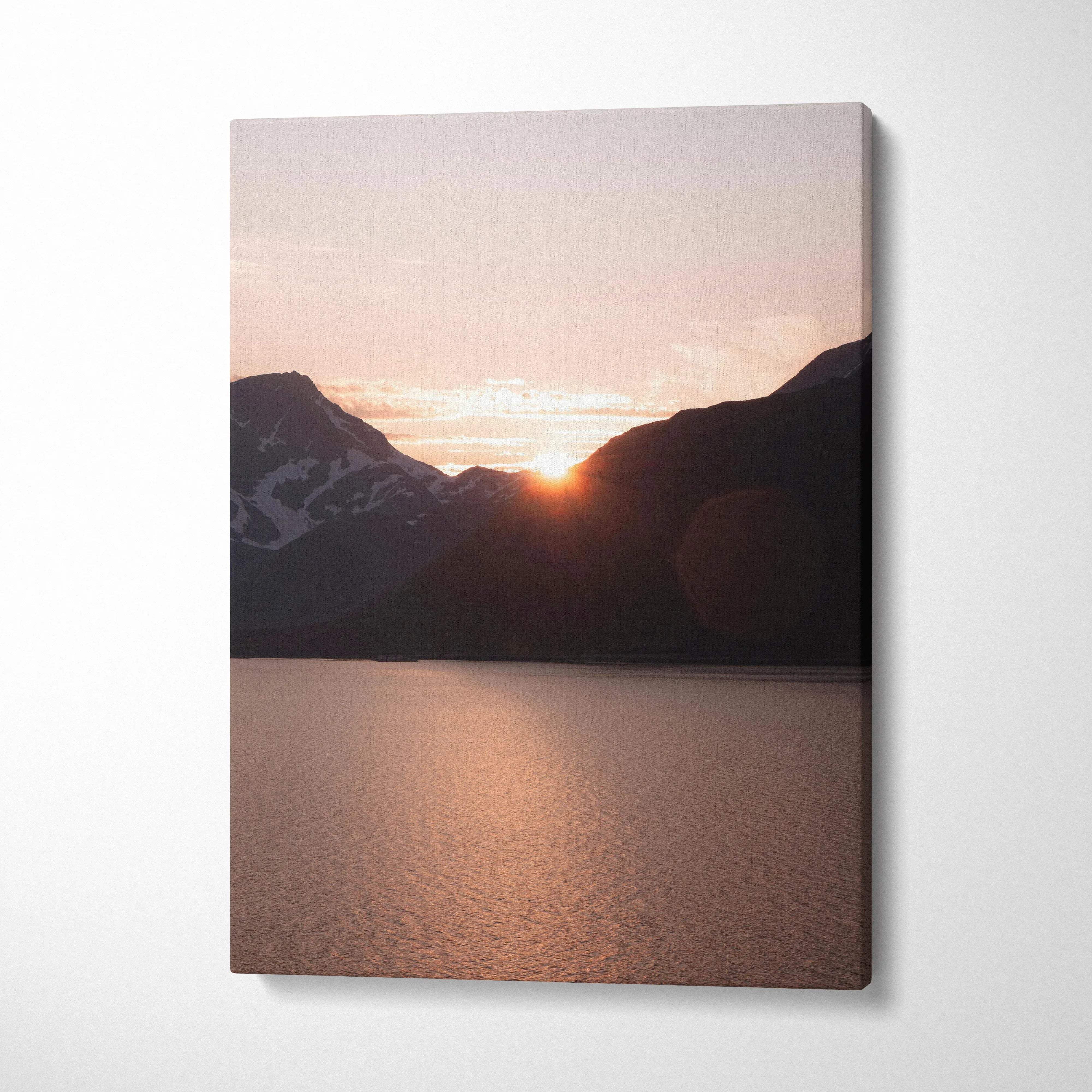 Canvas wall art featuring a serene mountain sunset with soft pink and orange hues over calm water.