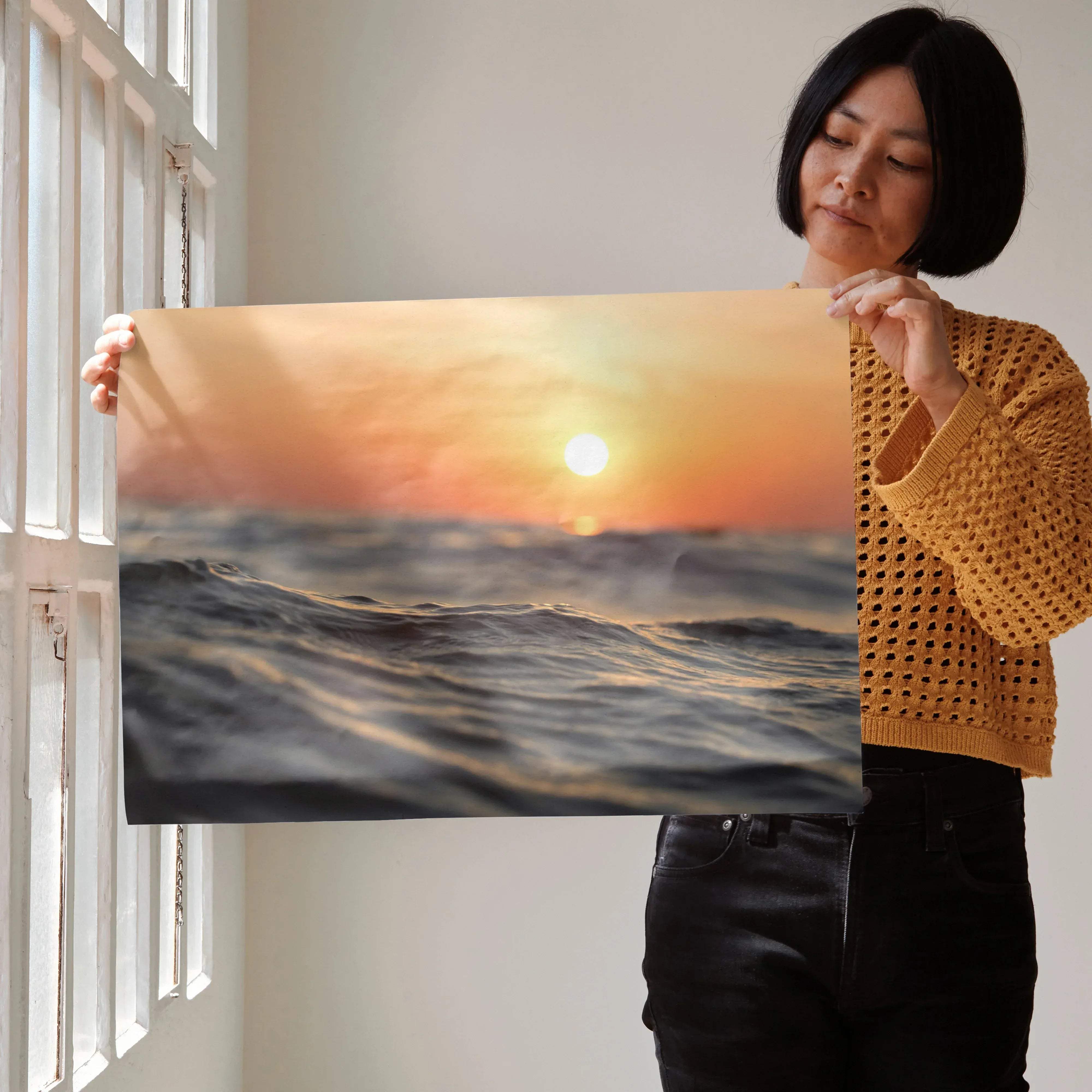 A rectangular canvas print of serene ocean horizon wall art featuring a warm orange sunset over dark textured waves