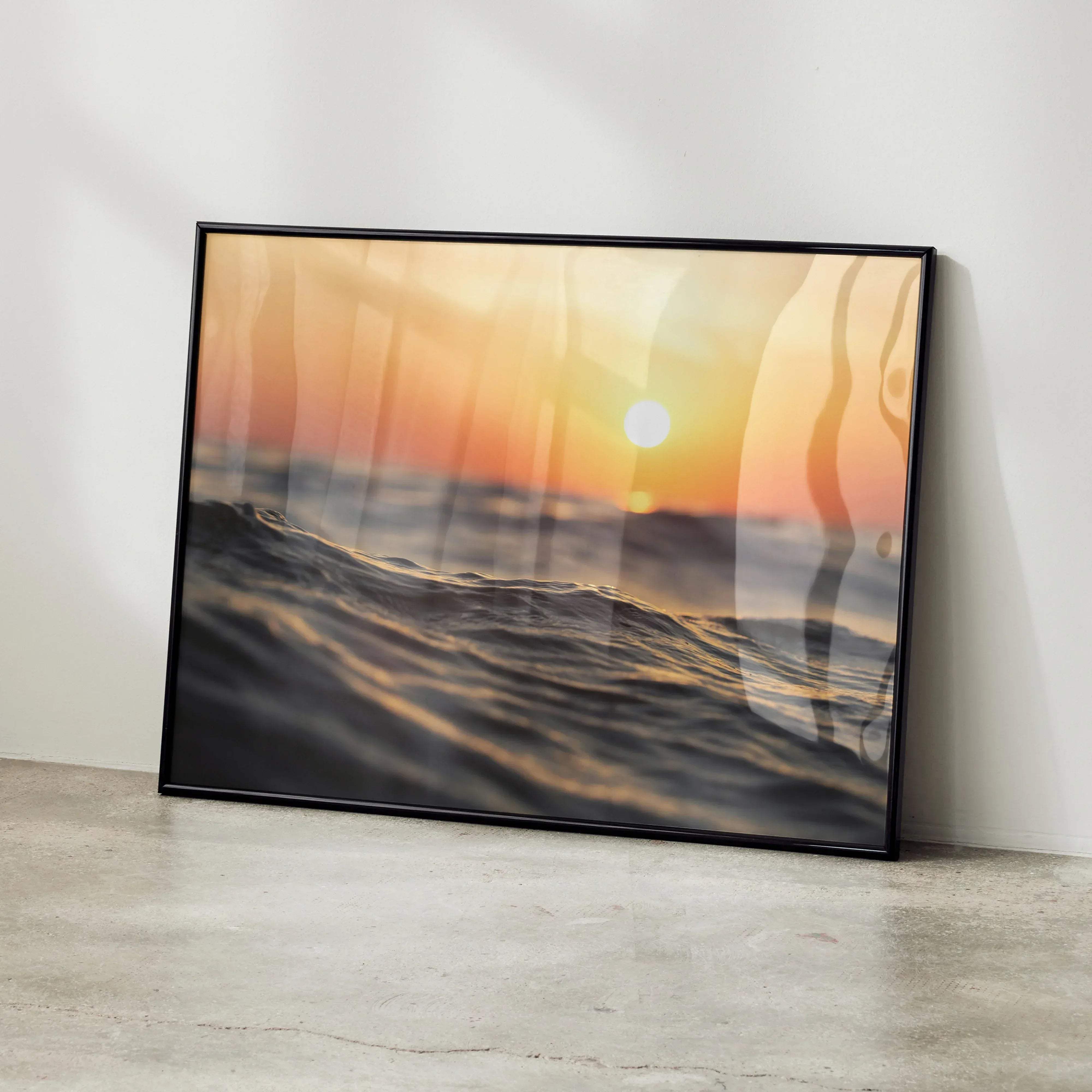 Black-framed serene ocean horizon wall art poster featuring a warm orange and golden sunset over ocean waves