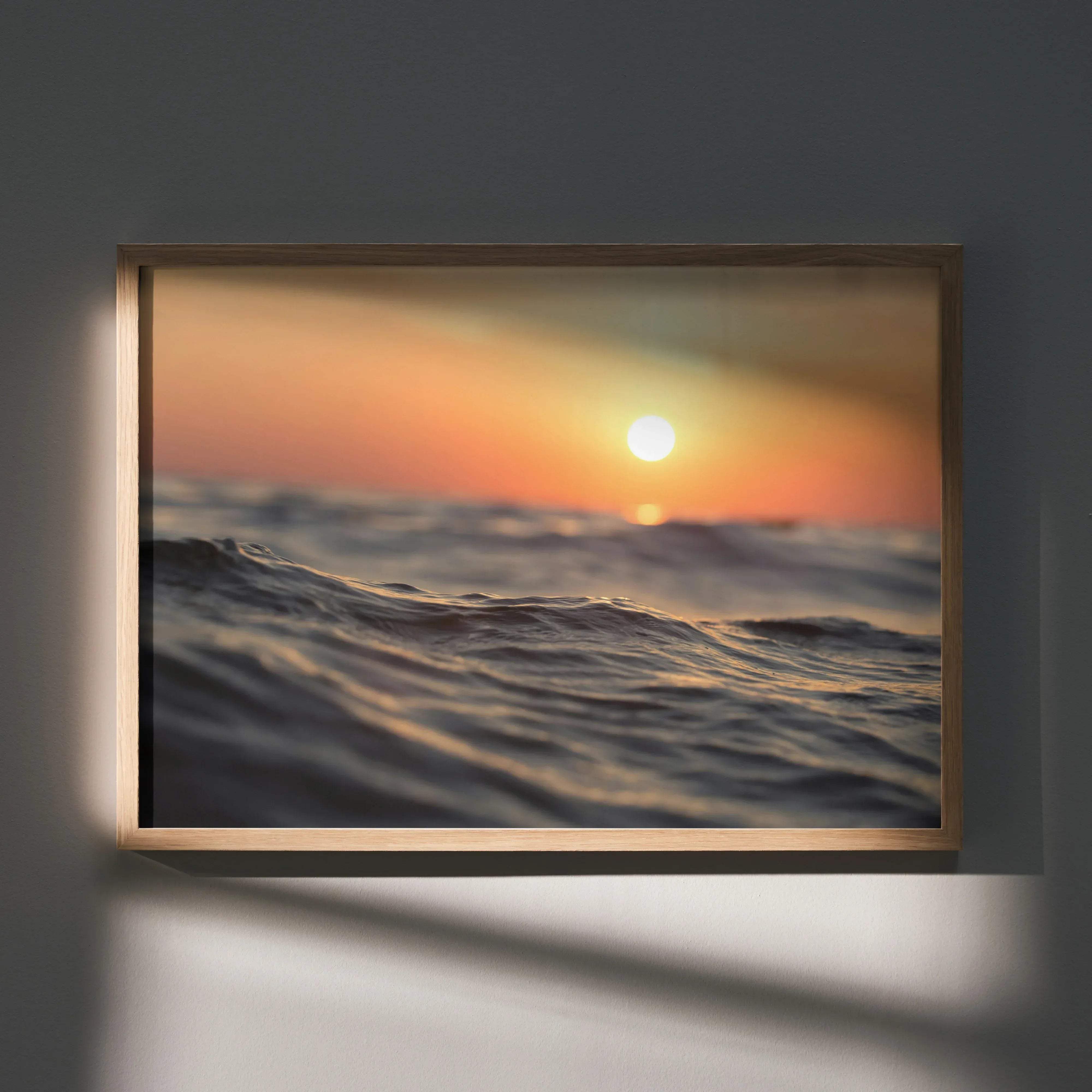Serene ocean horizon wall art poster depicting a sunset over ocean waves in a light wood rectangular frame
