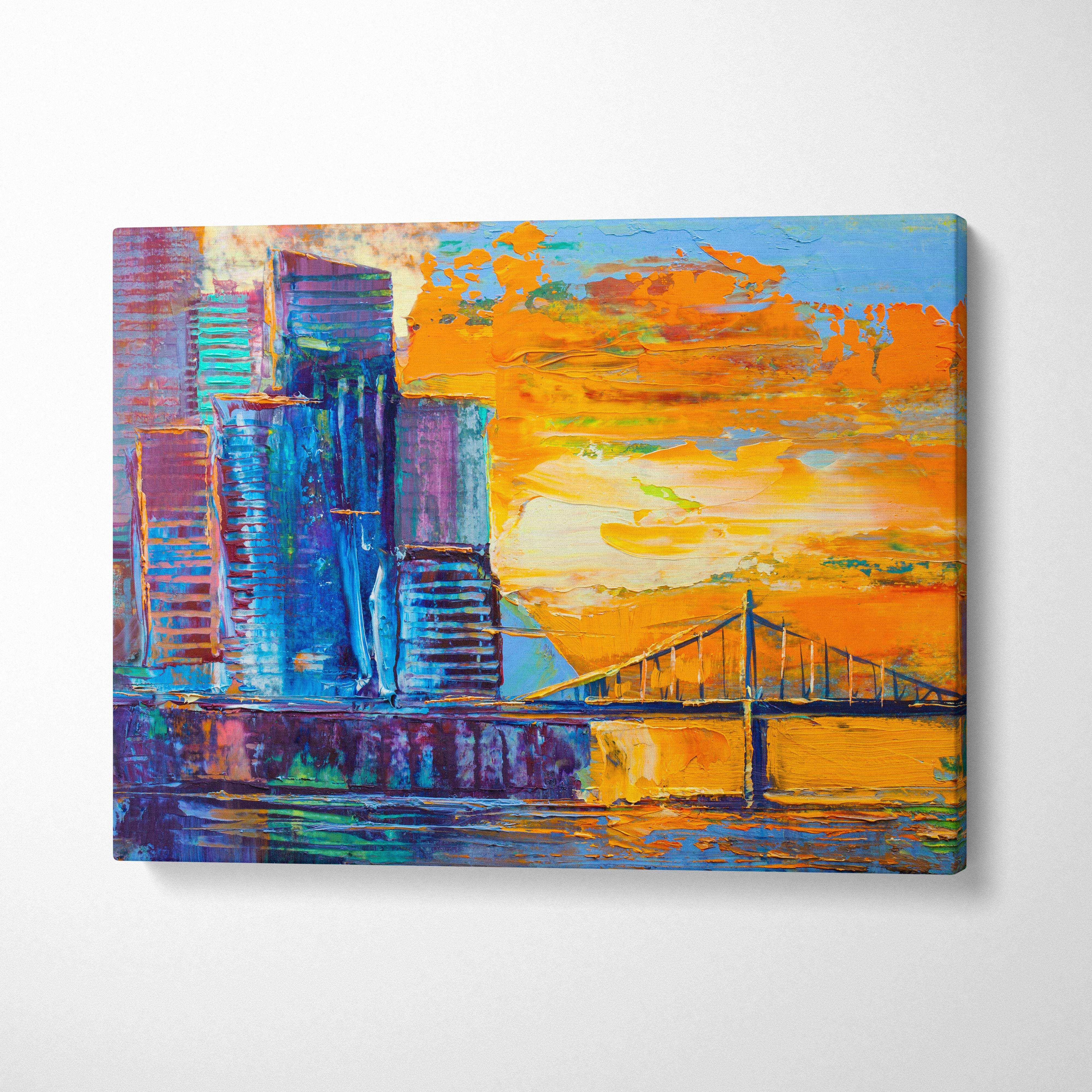 Modern abstract city skyline canvas print featuring bold blue and purple skyscrapers with orange sunset and bridge