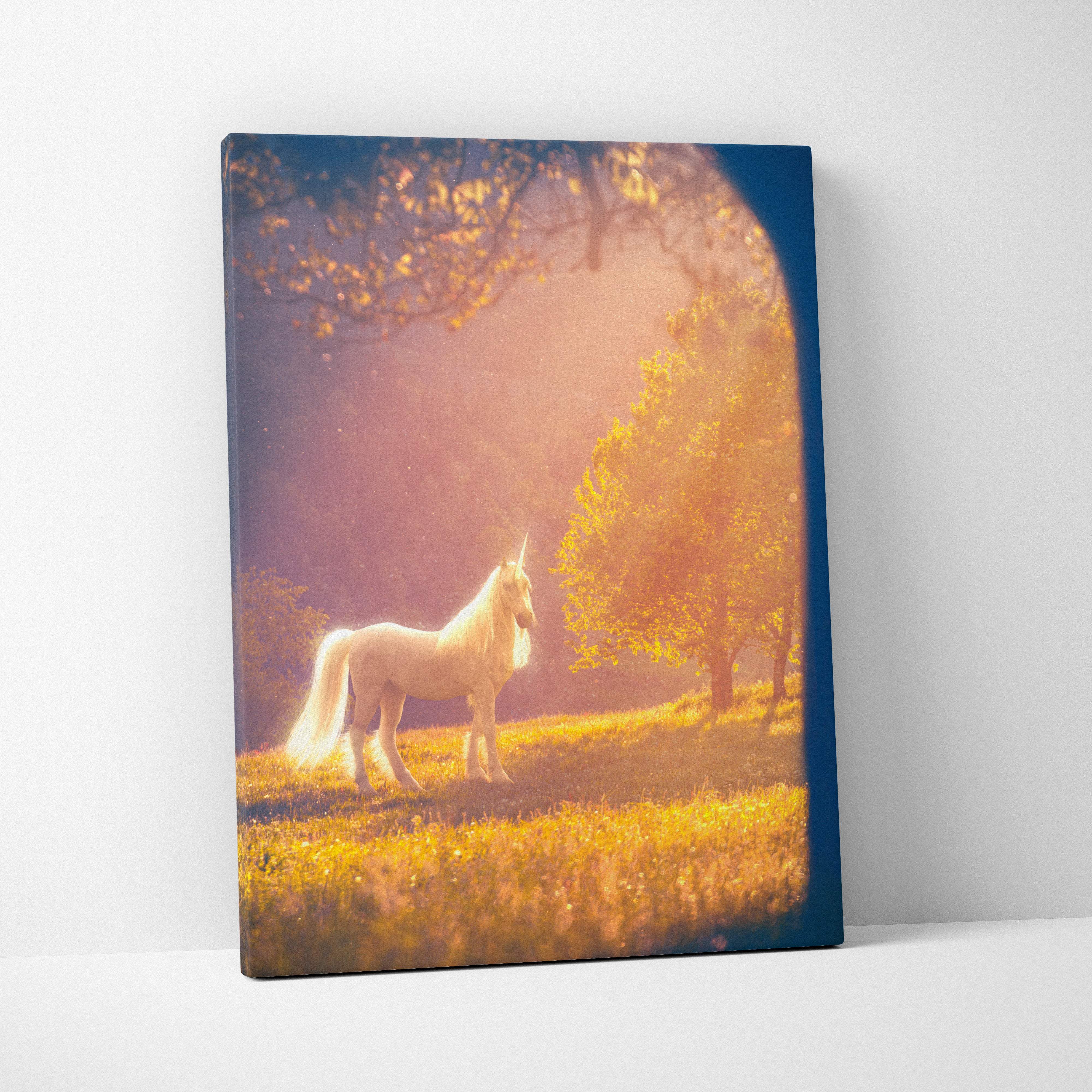 A rectangular canvas print of a white unicorn standing in a golden meadow with sunlight in a sunlit forest