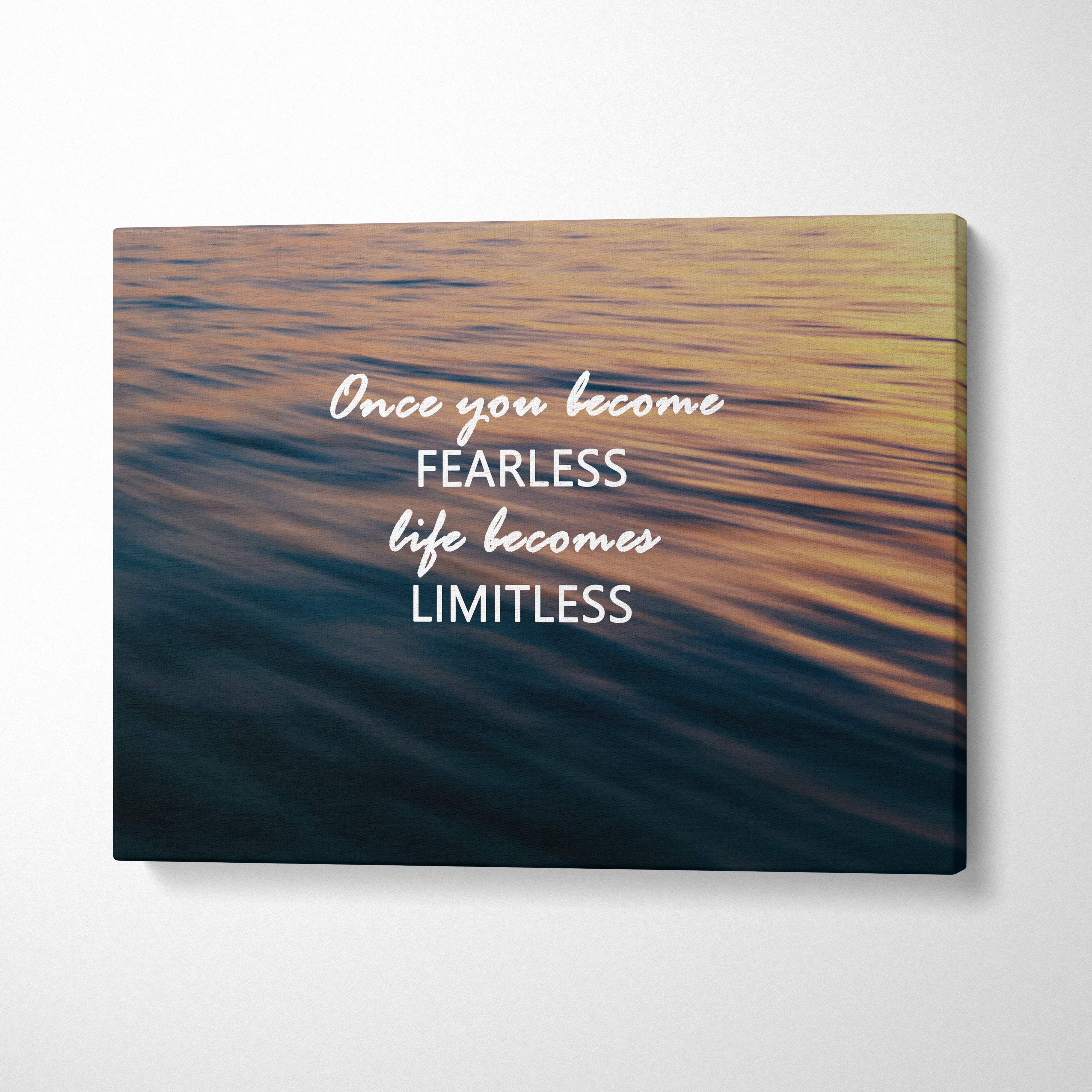 Fearless and limitless motivational canvas print with blurred golden and deep blue ocean scene and white script quote for home decor