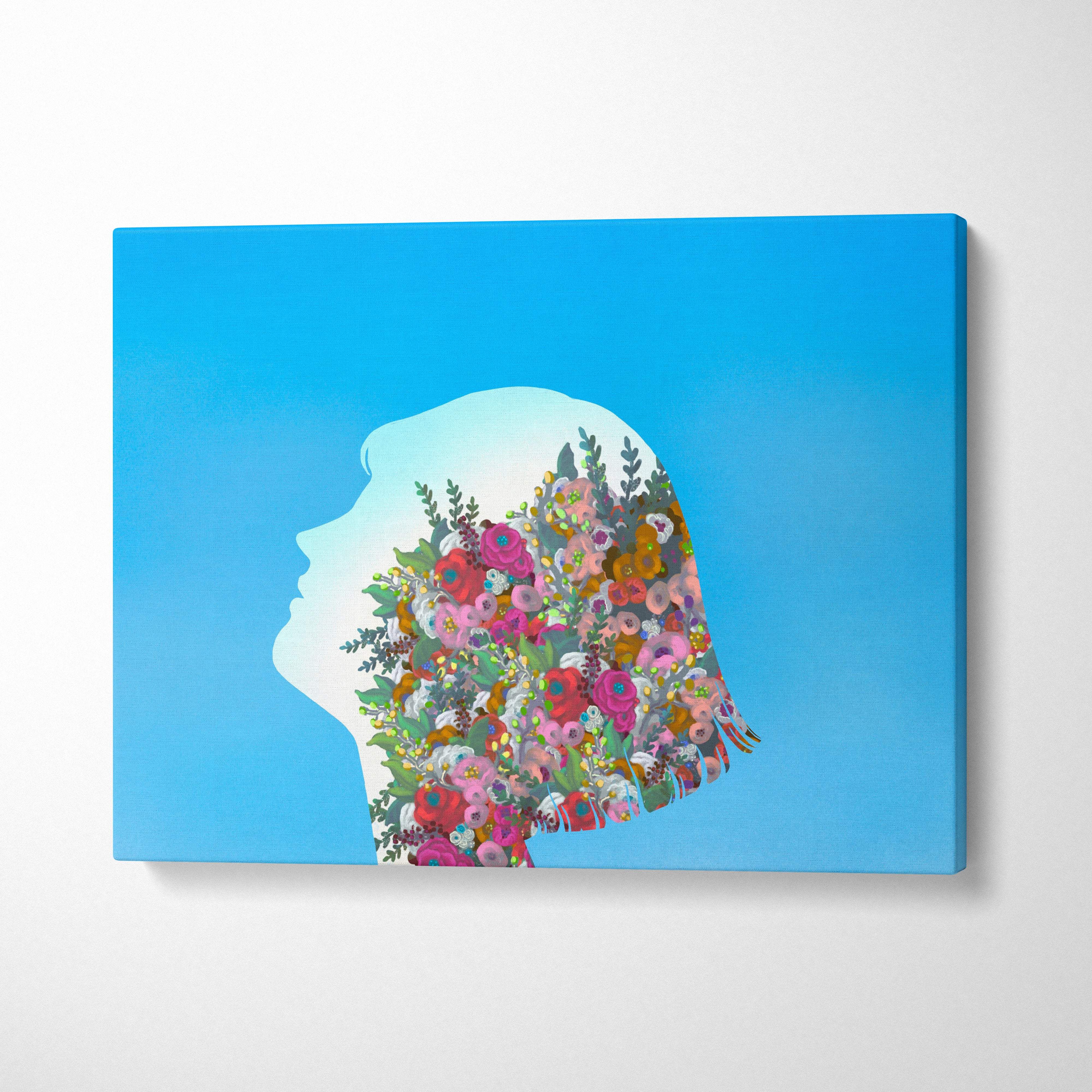 A vibrant floral silhouette canvas print of a woman’s profile with colorful blossoms on blue background for bedroom decor