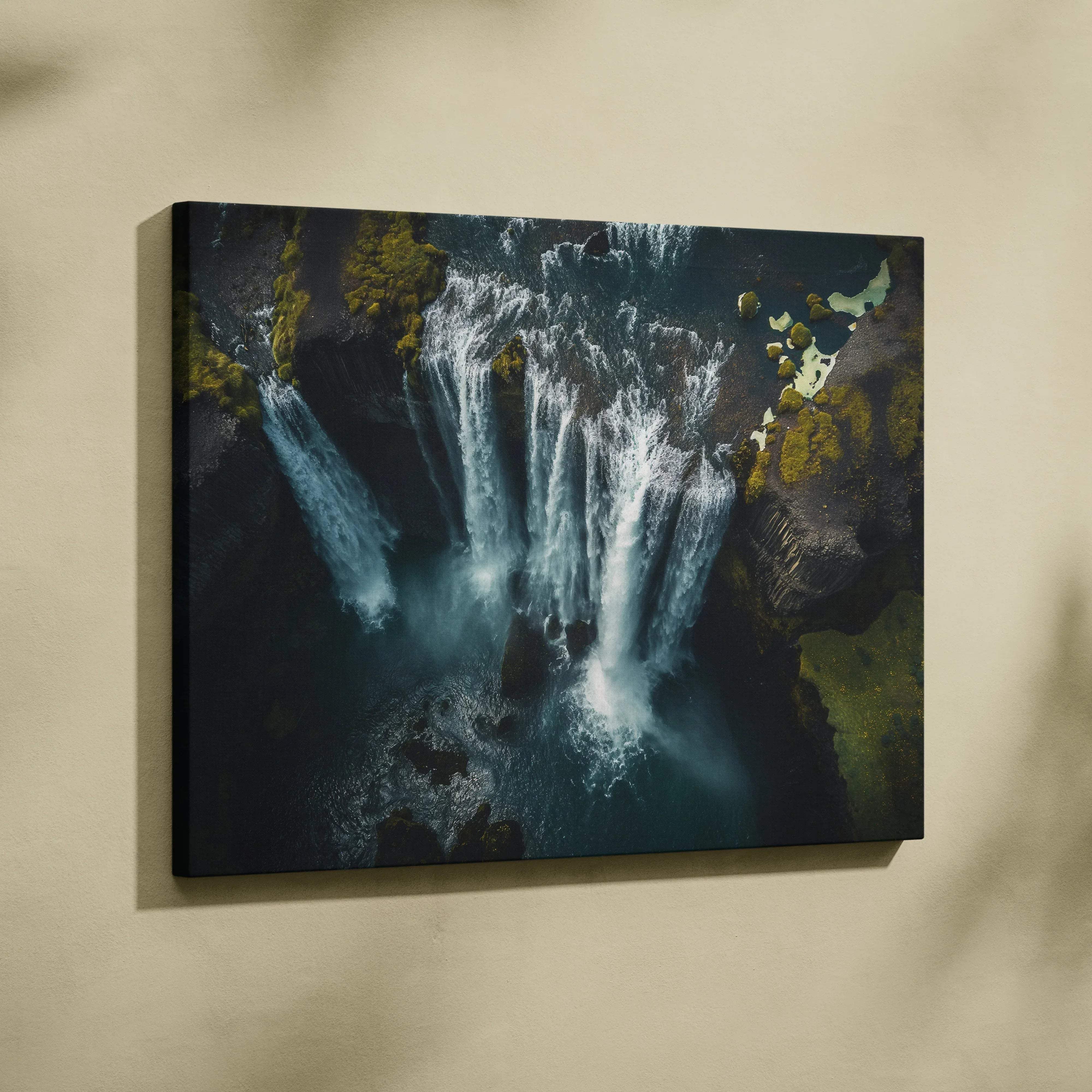 A rectangular canvas wall art featuring an aerial view of iceland waterfalls with moody blues teal tones and mossy rocks