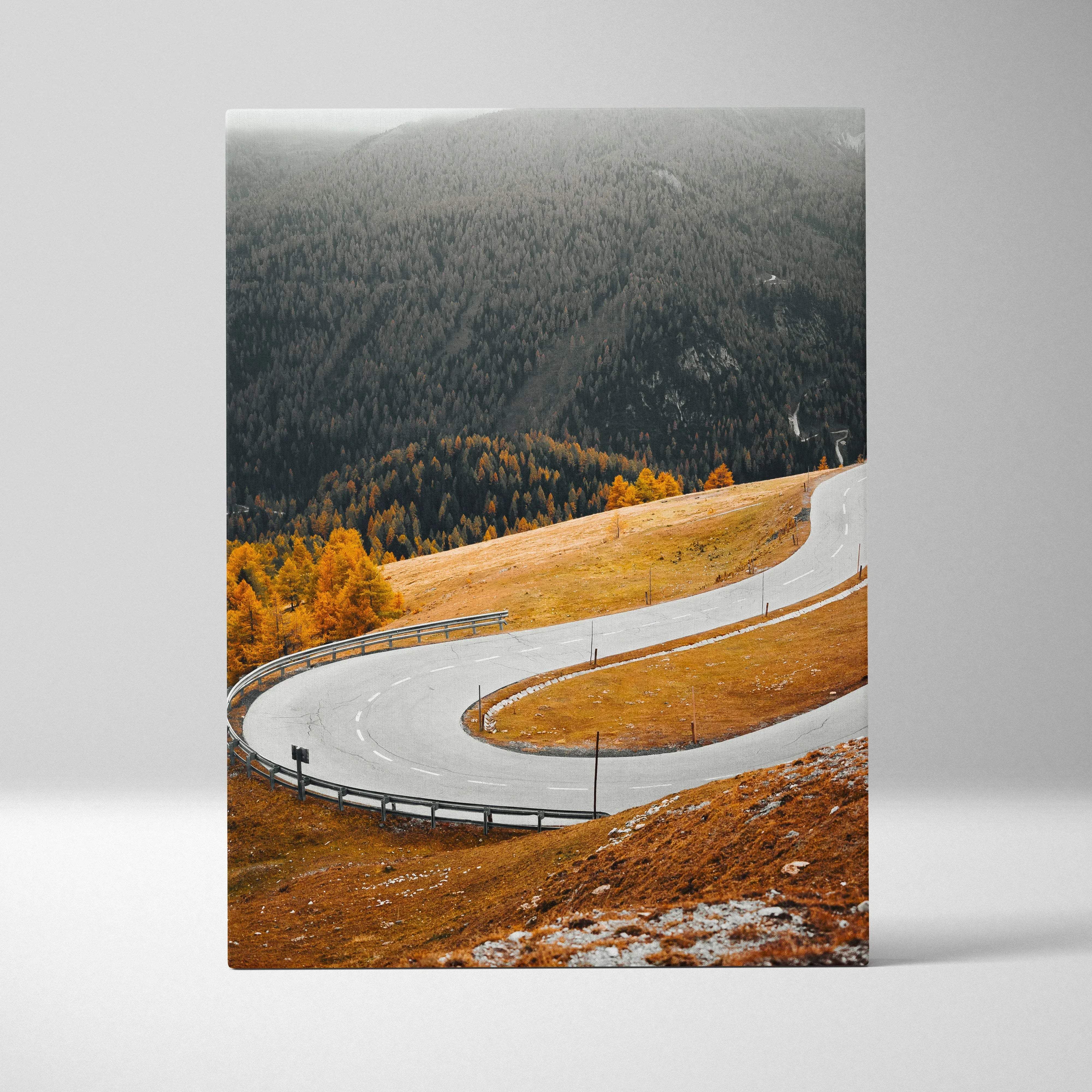 A framed autumn landscape canvas wall art featuring a winding mountain road through golden foliage and misty peaks